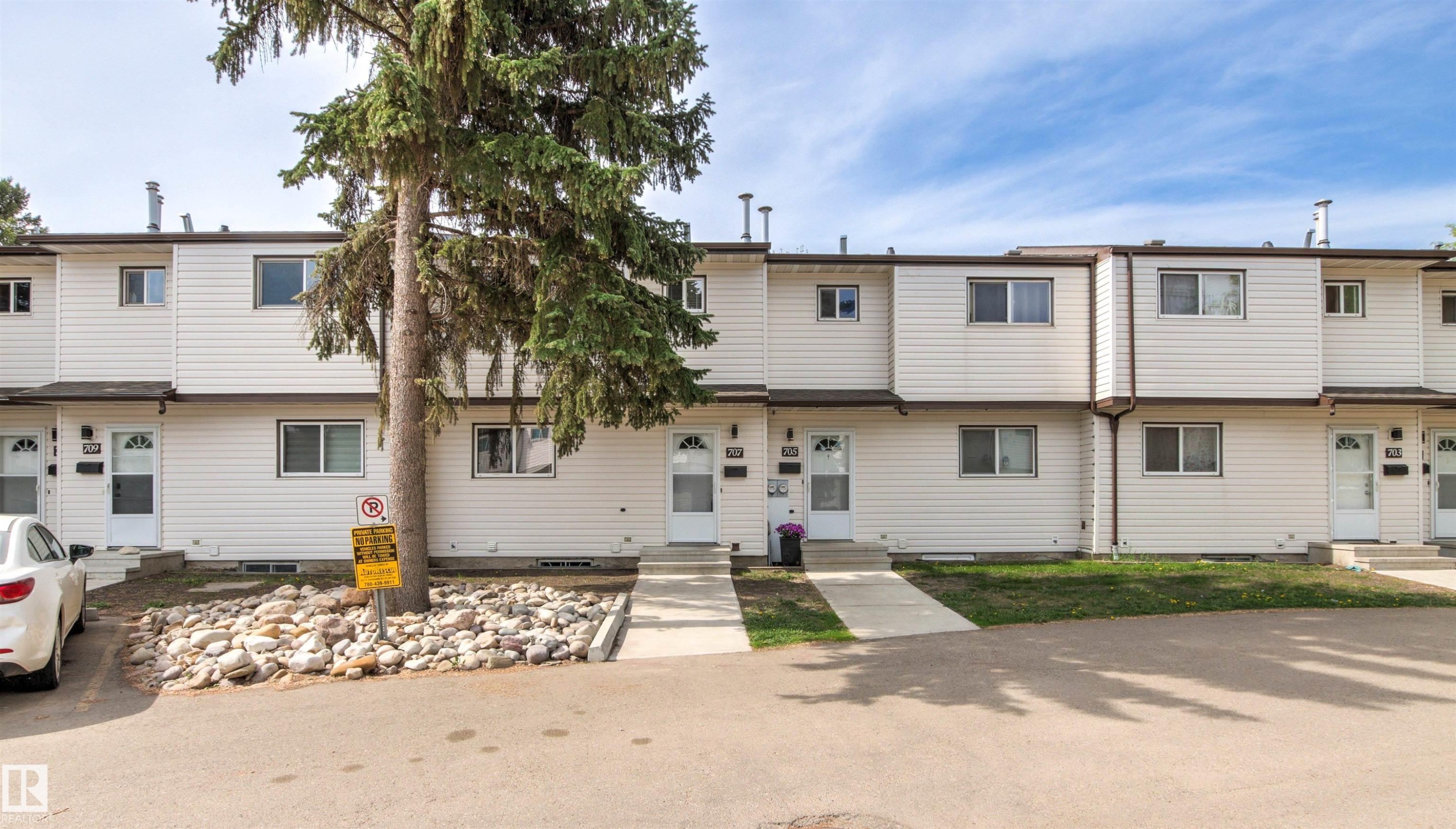 Townhouse-style exterior featuring white horizontal siding and brown trim - 707 Clareview Road, Edmonton, AB - Outdoor With Facade