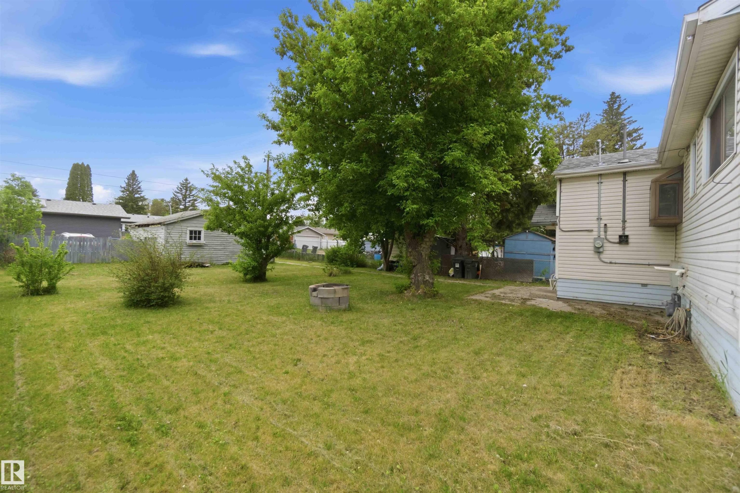 Expansive grassy yard featuring mature trees and shrubbery - 16 Michigan Street, Devon, AB - Outdoor
