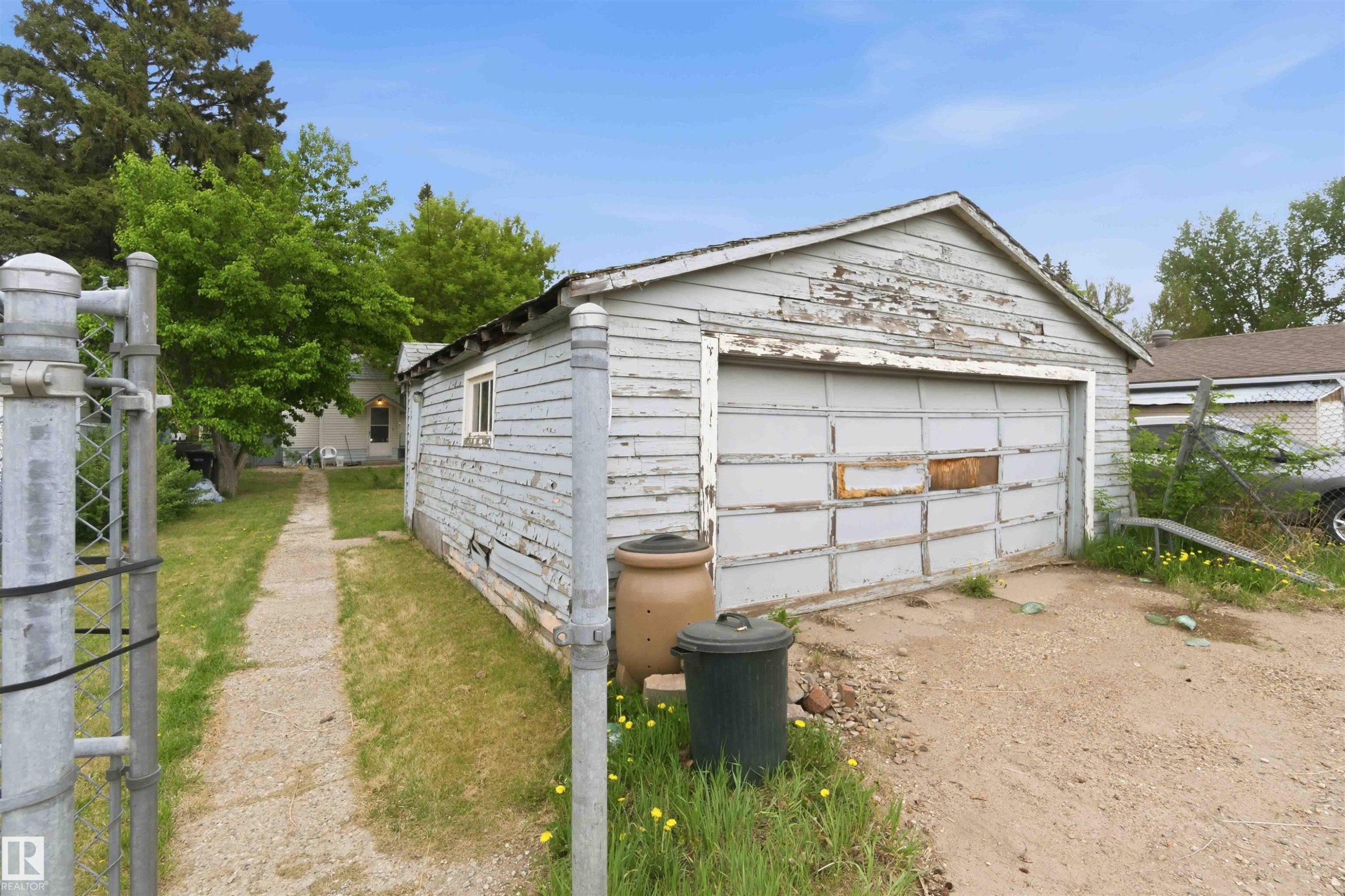 Detached garage structure with a single bay door and an adjacent walkway leading to the main residence - 16 Michigan Street, Devon, AB - Outdoor