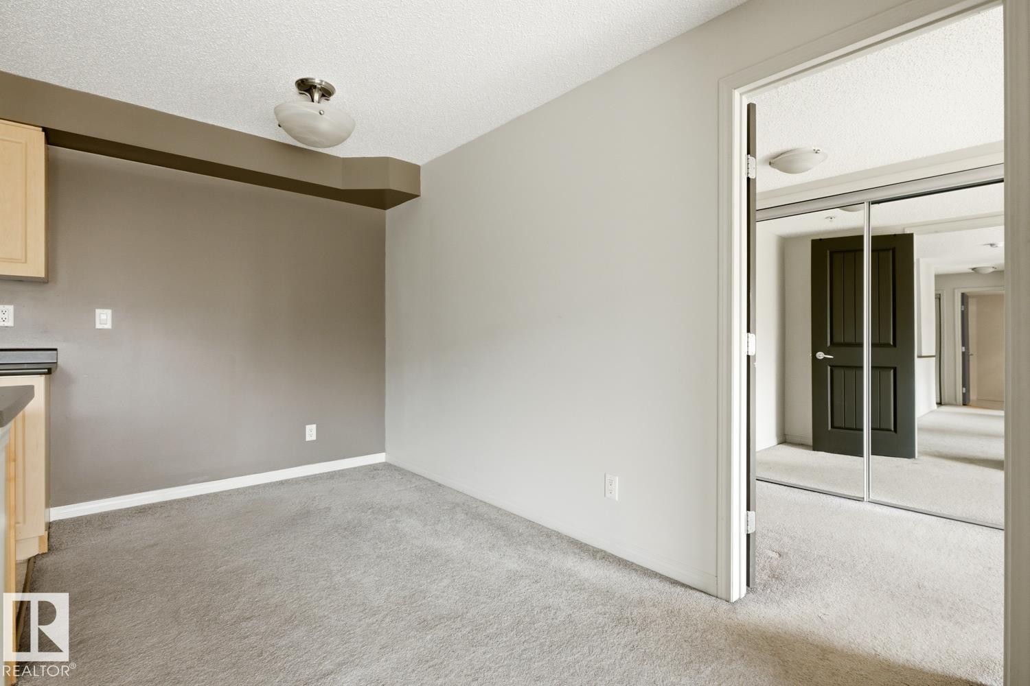 Carpeted room with light grey walls and a contrasting accent wall - #312 13908 136 St Nw, Edmonton, AB - Indoor
