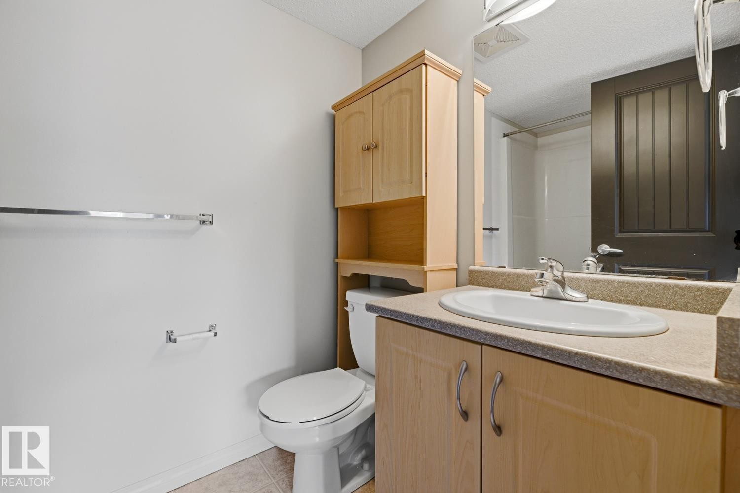 Bathroom vanity with an integrated sink, laminate countertop, and wood-finish cabinetry - #312 13908 136 St Nw, Edmonton, AB - Indoor Photo Showing Bathroom