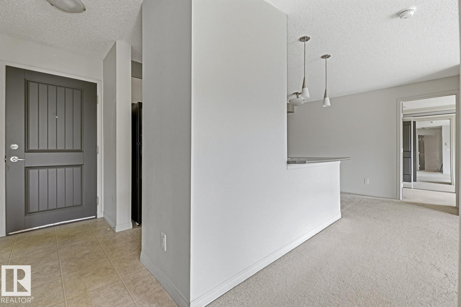 Entryway featuring a paneled door with brushed nickel hardware, leading to a tiled floor - #312 13908 136 St Nw, Edmonton, AB - Indoor Photo Showing Other Room