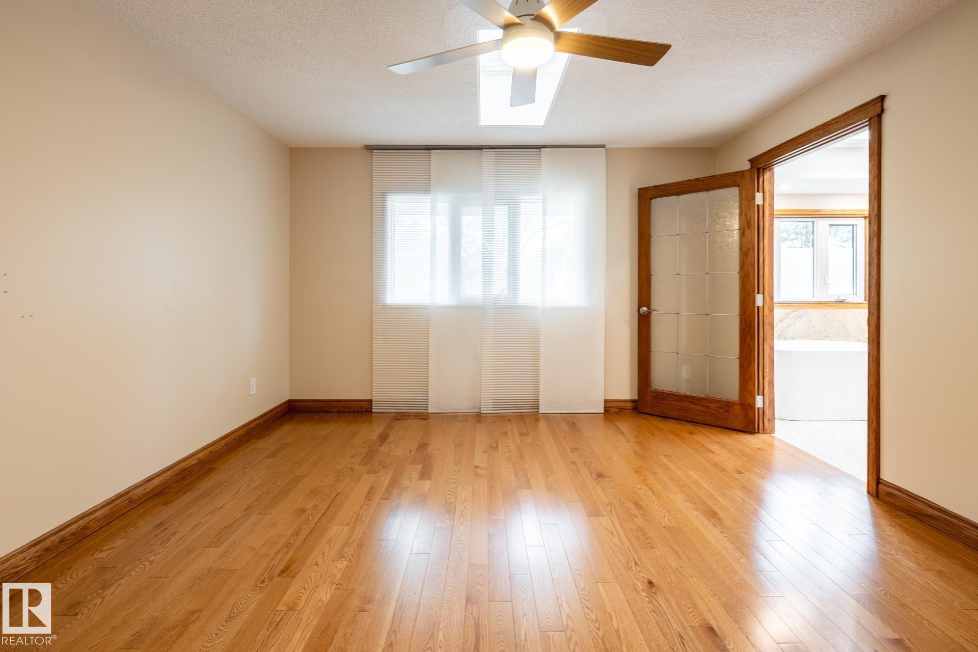 Hardwood flooring with matching baseboards and door trim - 4632 151 Street, Edmonton, AB - Indoor Photo Showing Other Room