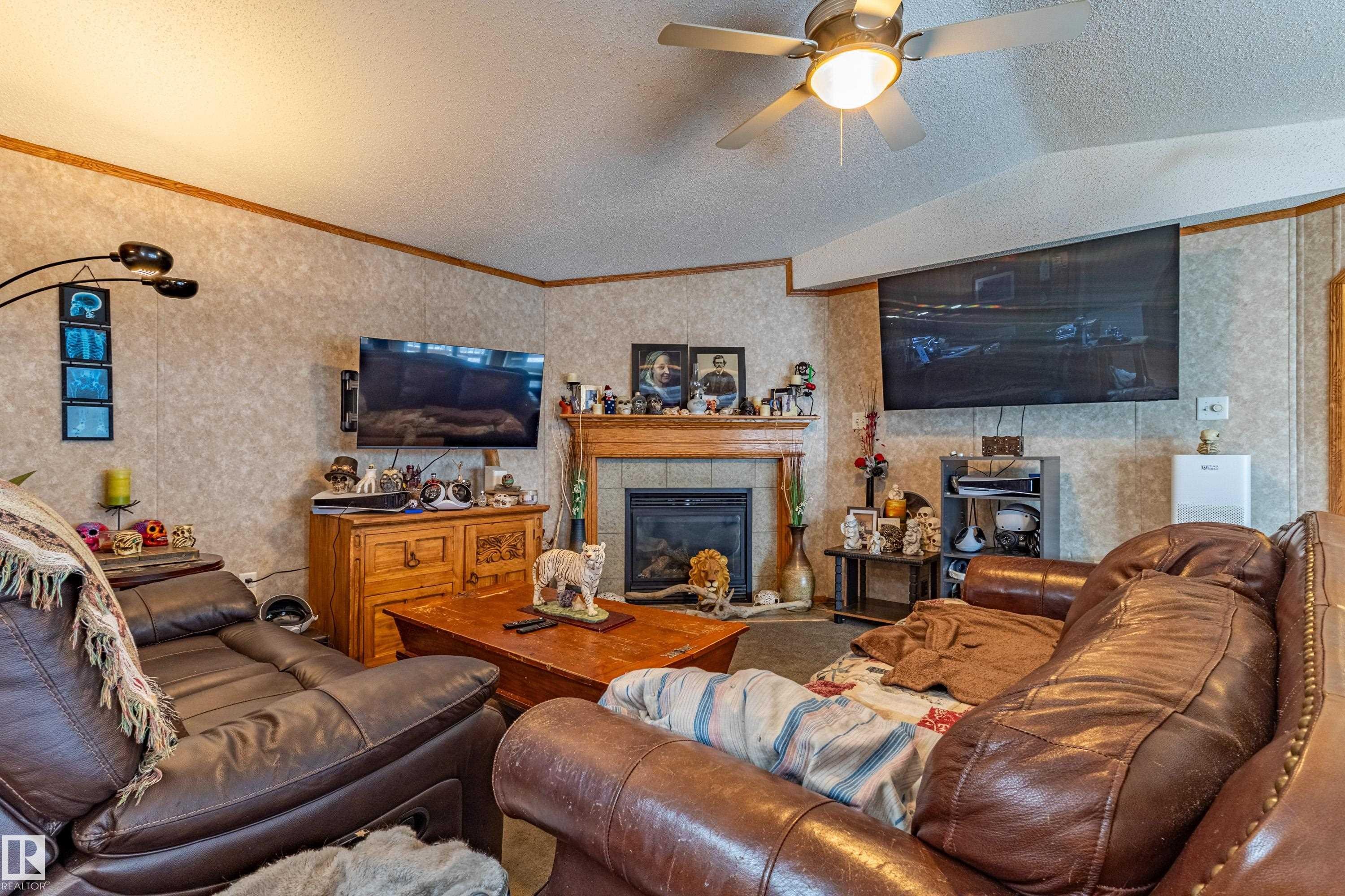 Living area featuring a fireplace with a wood mantel, tiled surround, and hearth - 1529 Range Road 272 Rural Parkland County, Alberta, Rural Parkland County, AB - Indoor Photo Showing Living Room With Fireplace