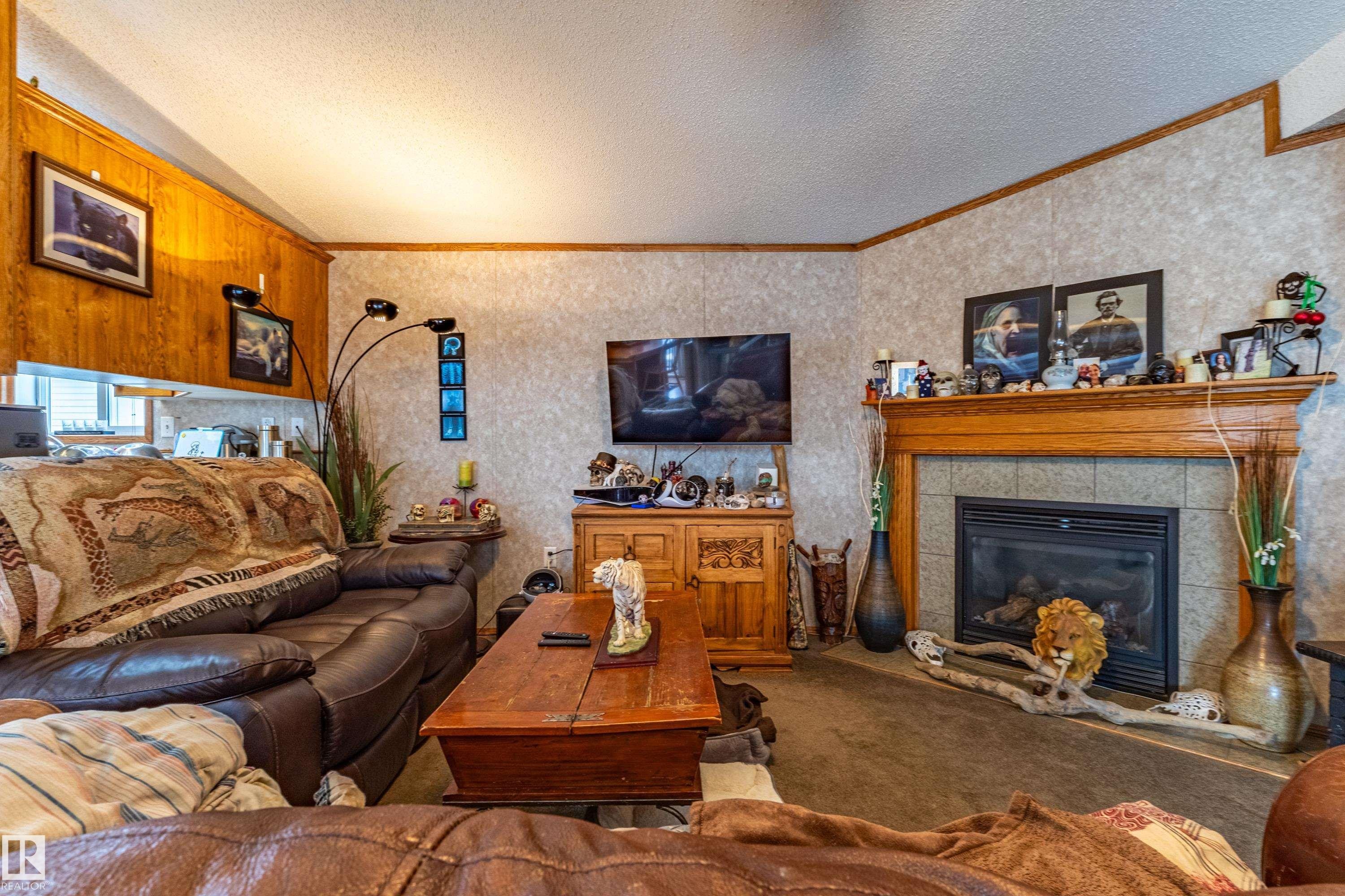 Living area featuring a central fireplace with a wood mantle and tile surround - 1529 Range Road 272 Rural Parkland County, Alberta, Rural Parkland County, AB - Indoor Photo Showing Living Room With Fireplace