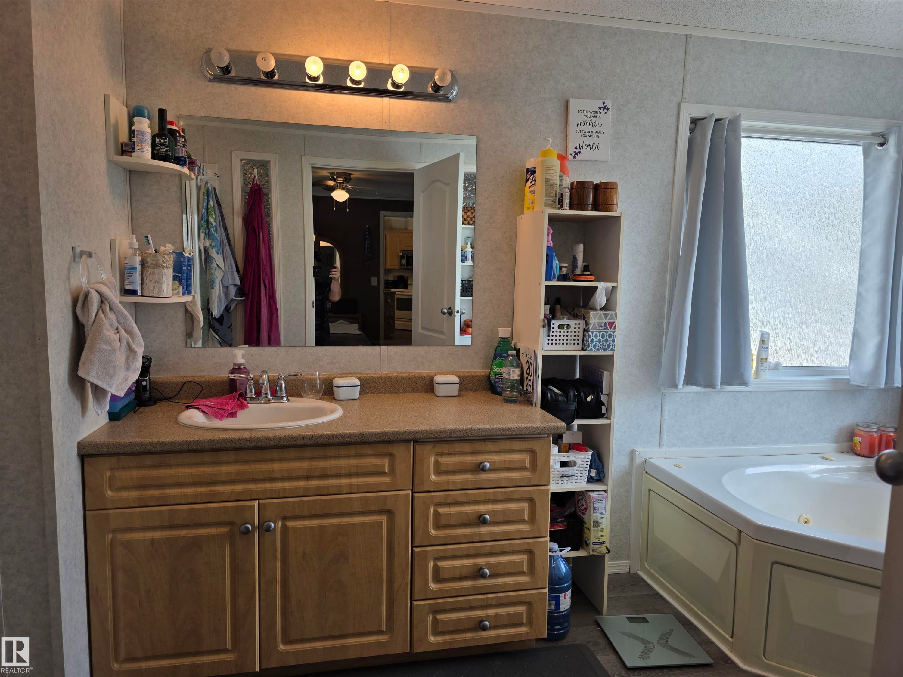 Bathroom vanity with a light wood-finish cabinet and integrated sink - 5012 53 Ave, Breton, AB