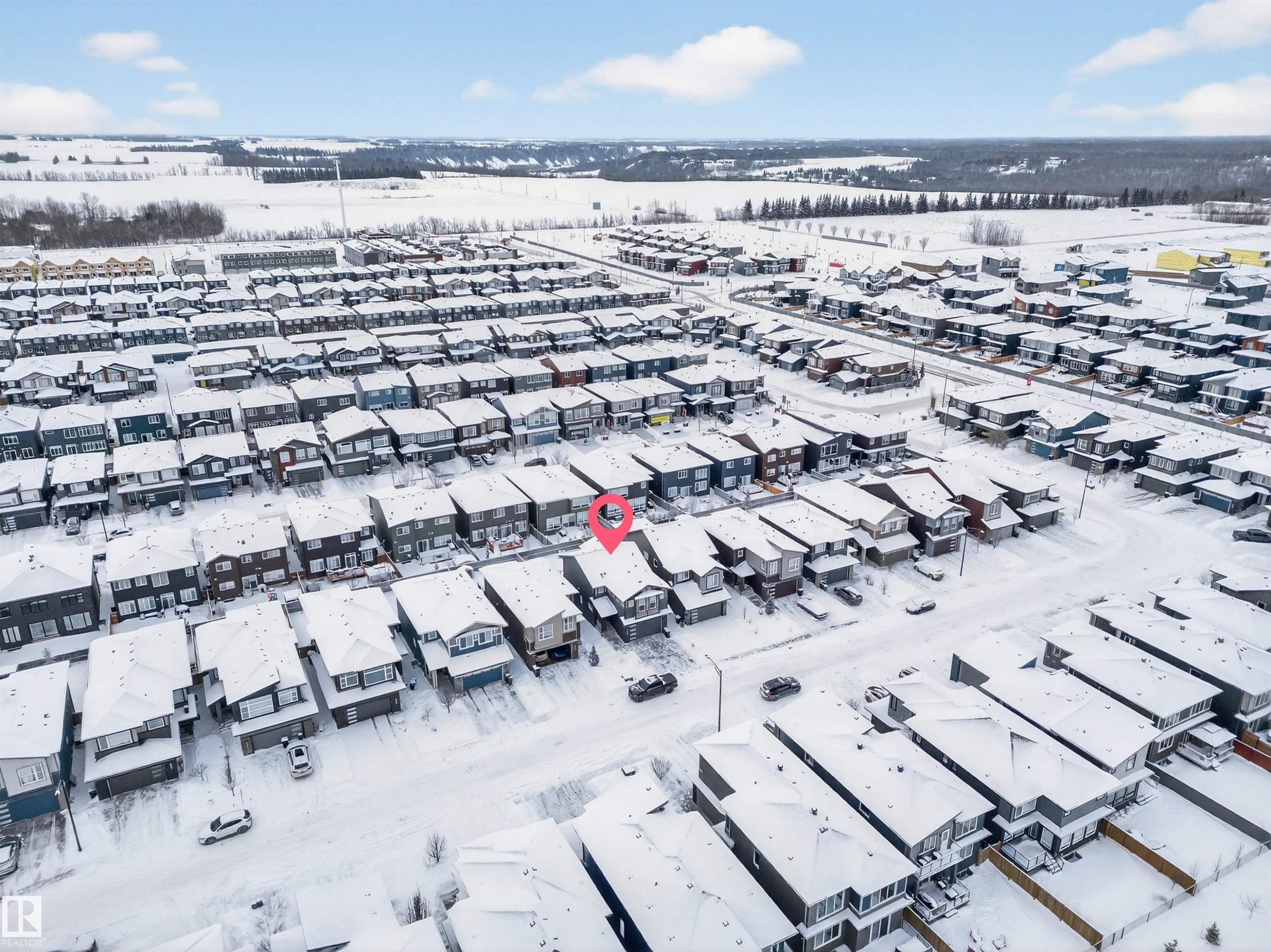 Residential neighborhood featuring multiple detached homes with snow-covered roofs and a distant treeline - 6085 King Landing, Edmonton, AB - Outdoor With View