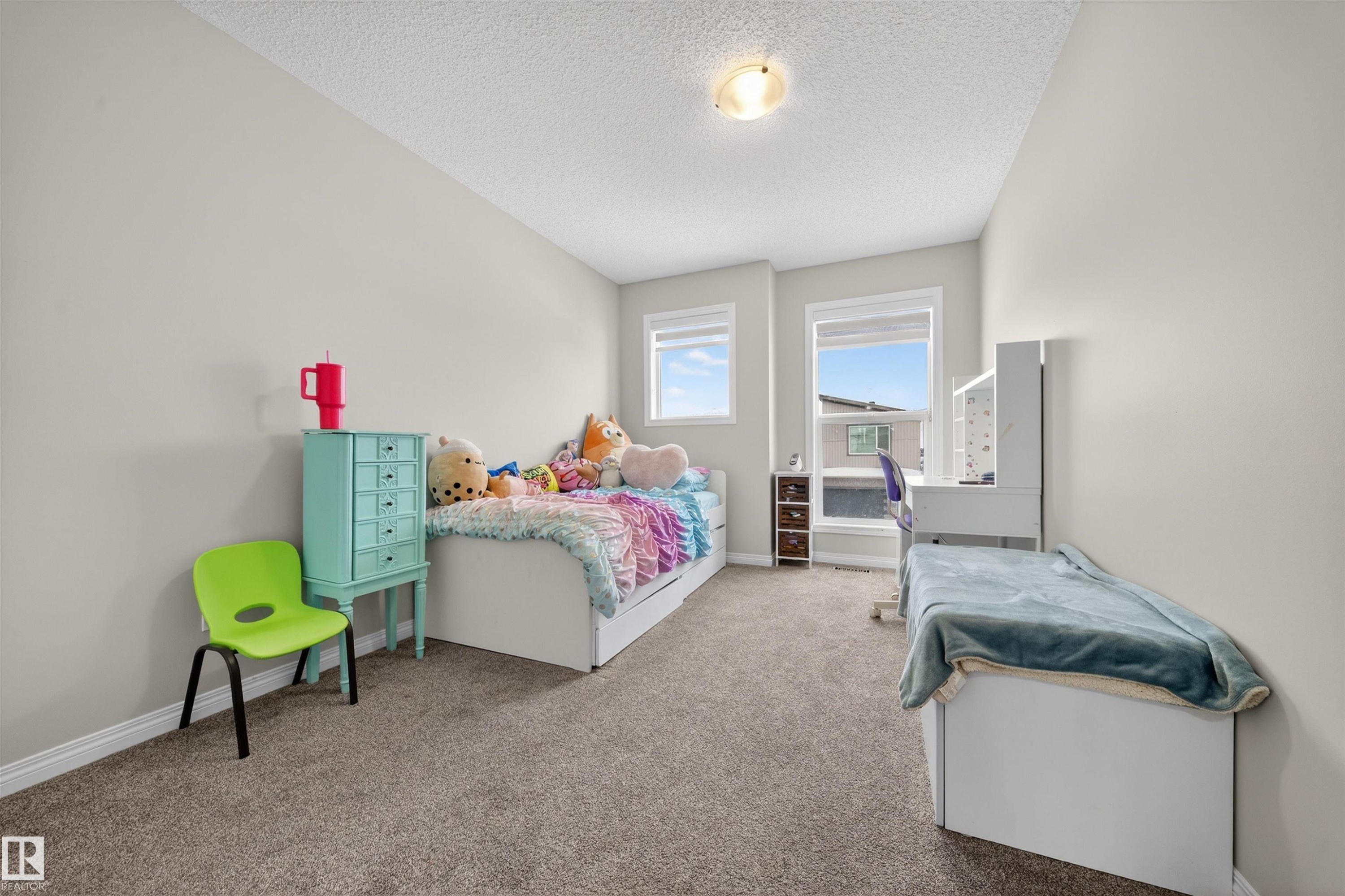 Carpeted room featuring light neutral wall paint, white trim, and a textured ceiling - 6085 King Landing, Edmonton, AB - Indoor Photo Showing Bedroom