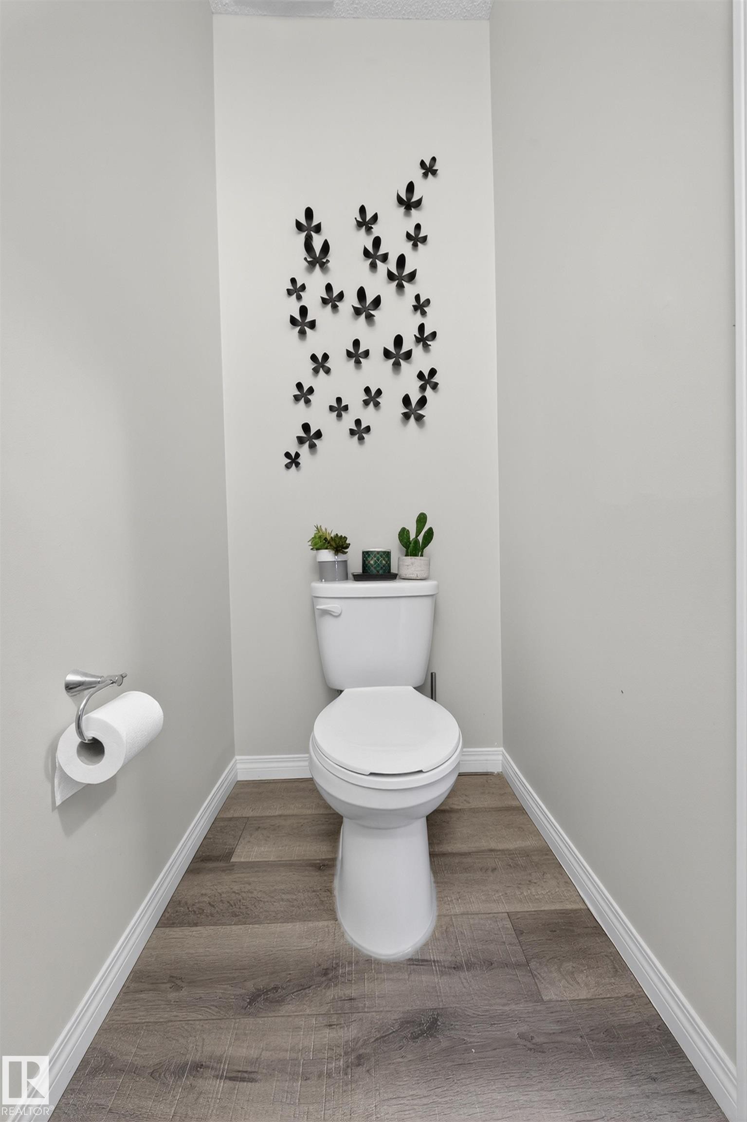 Powder room featuring light gray walls, wood-finish flooring, and crisp white baseboards - 6085 King Landing, Edmonton, AB - Indoor Photo Showing Bathroom