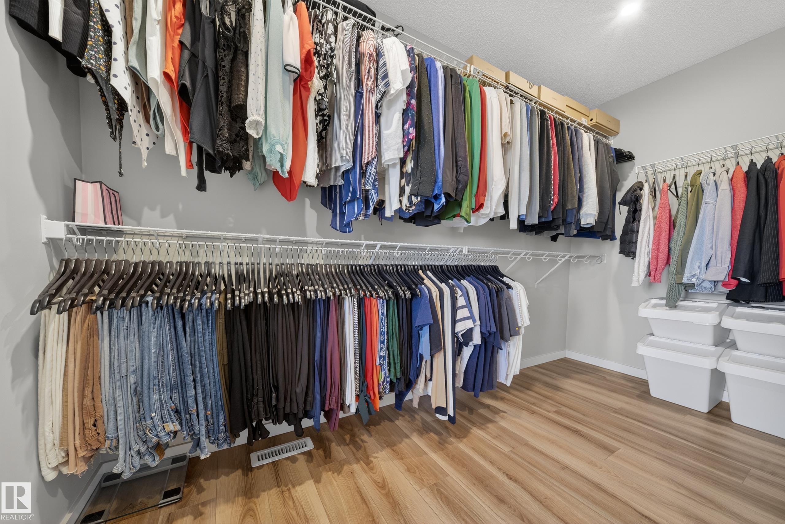 Spacious walk-in closet featuring light wood-finish flooring and light gray walls - 3337 Kulay Way, Edmonton, AB - Indoor With Storage