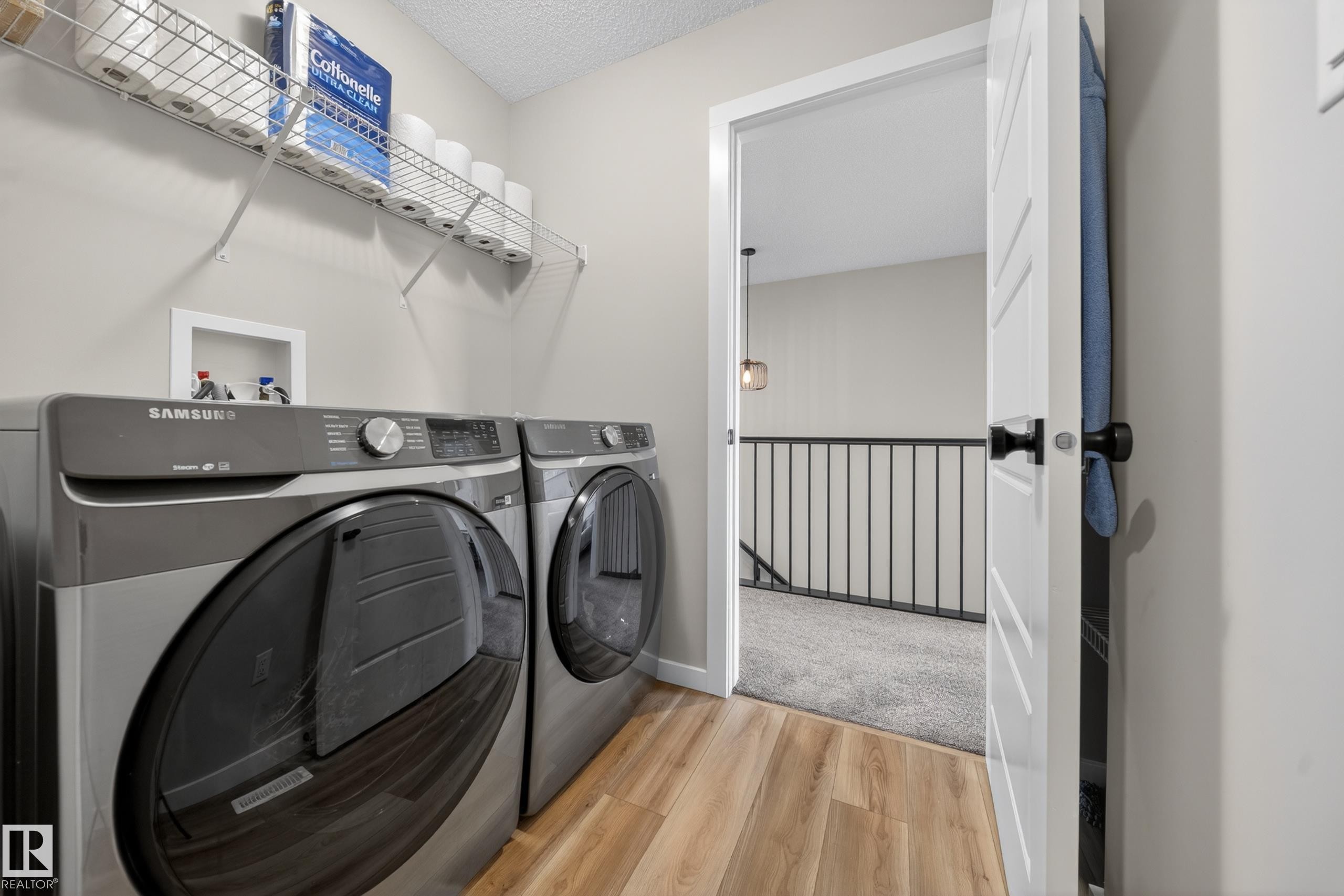Dedicated laundry area featuring wood-finish flooring and a wire storage shelf - 3337 Kulay Way, Edmonton, AB - Indoor Photo Showing Laundry Room