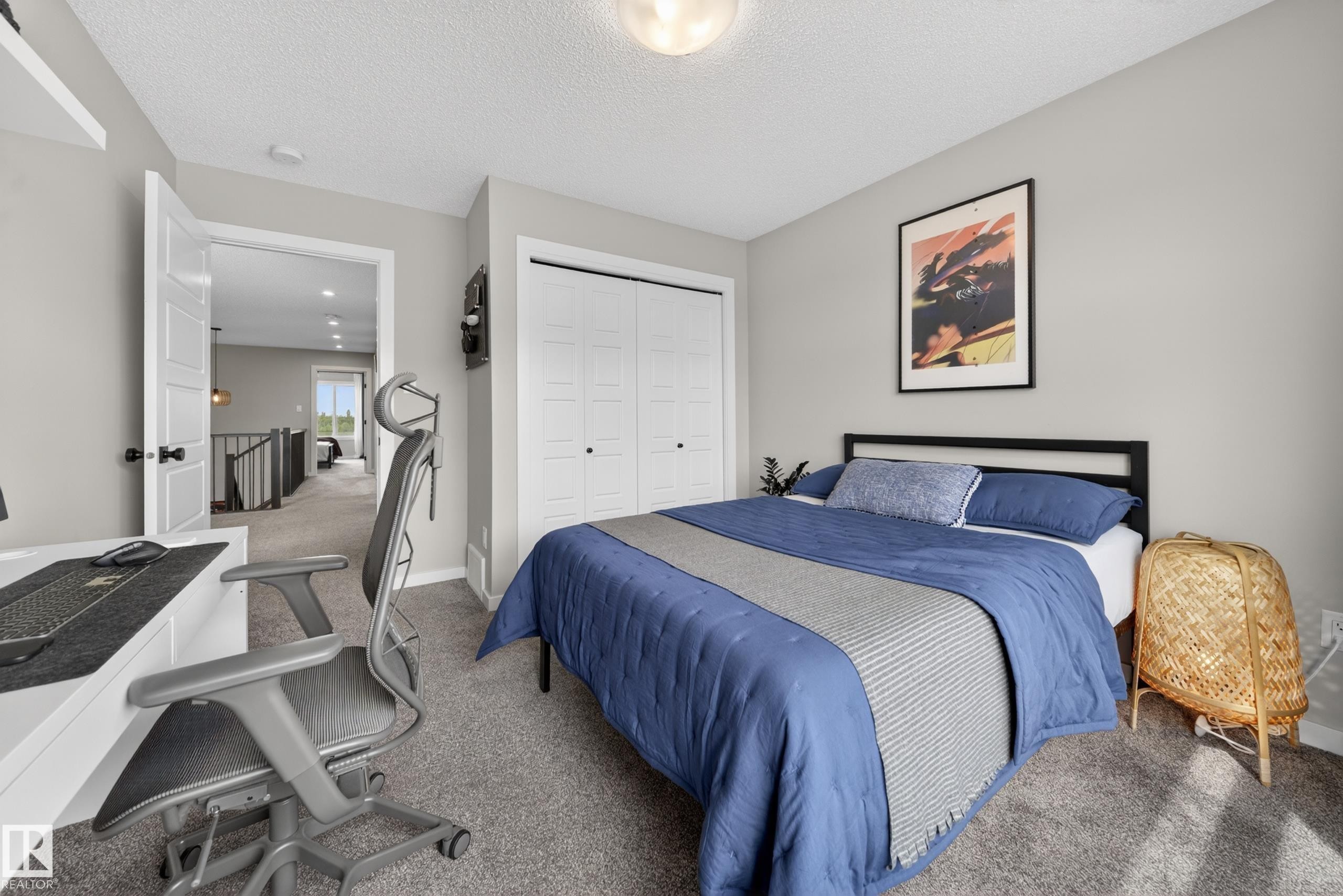 Carpeted bedroom featuring a double-door closet, light gray wall paint, and a built-in wall shelf - 3337 Kulay Way, Edmonton, AB - Indoor Photo Showing Bedroom