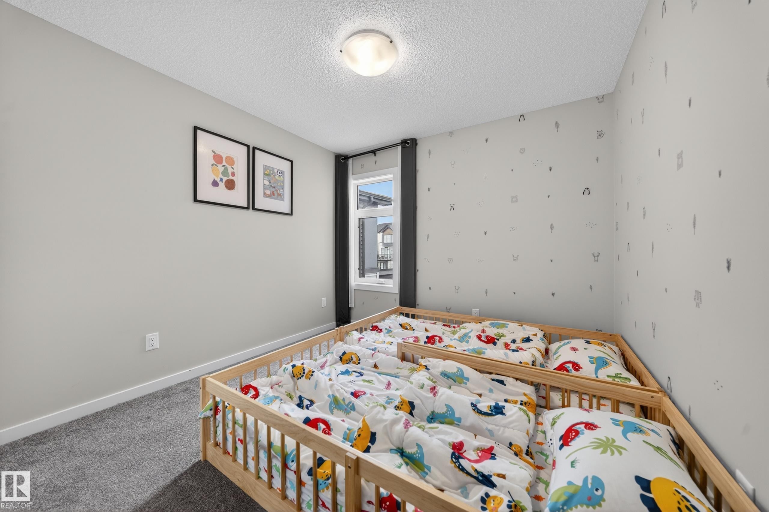 Bedroom featuring light gray wall paint, patterned wallpaper, a window with dark drapes, and gray carpeting - 3337 Kulay Way, Edmonton, AB - Indoor Photo Showing Bedroom