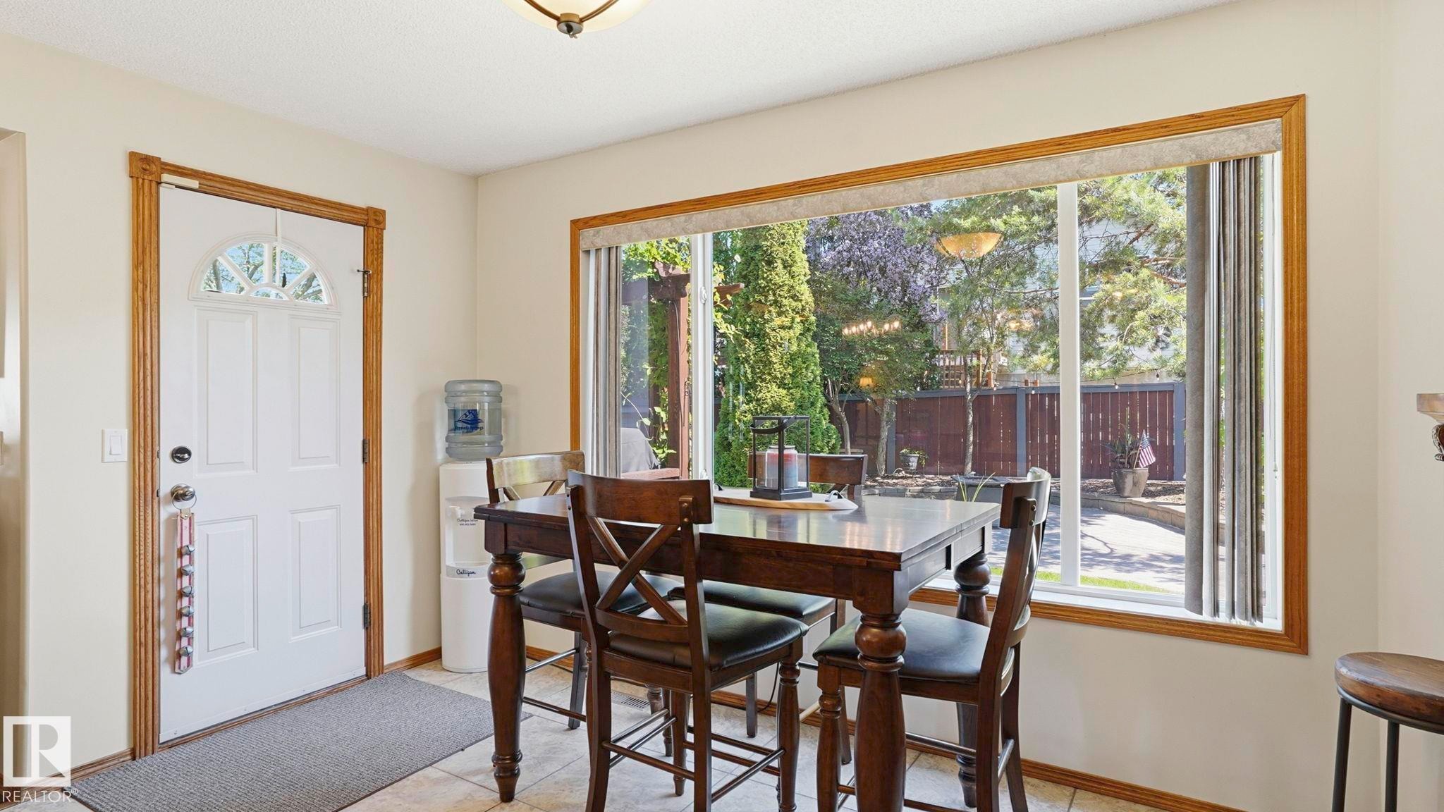 Dining area featuring a large window with wood-finish trim, providing exterior views - 4309 37A Avenue, Edmonton, AB - Indoor Photo Showing Dining Room
