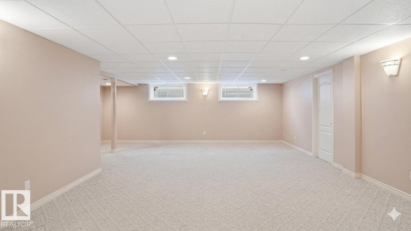 Spacious room featuring light-toned carpeting, neutral wall finishes, and a grid acoustic ceiling with recessed lighting - 4309 37A Avenue, Edmonton, AB - Indoor Photo Showing Basement