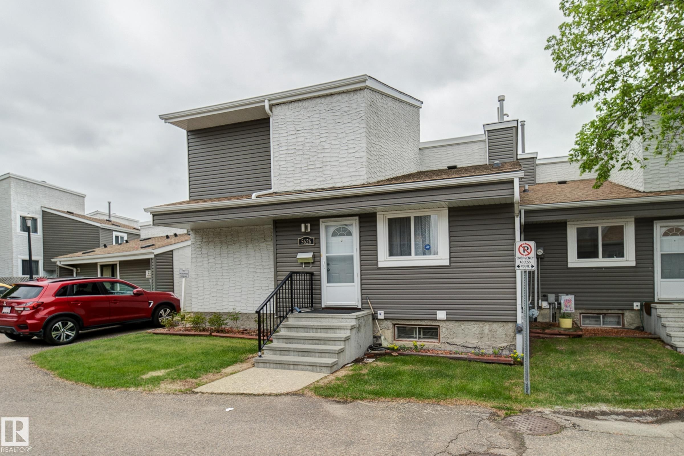 Multi-level exterior featuring horizontal siding and white brick accents - 5626 19A Avenue, Edmonton, AB