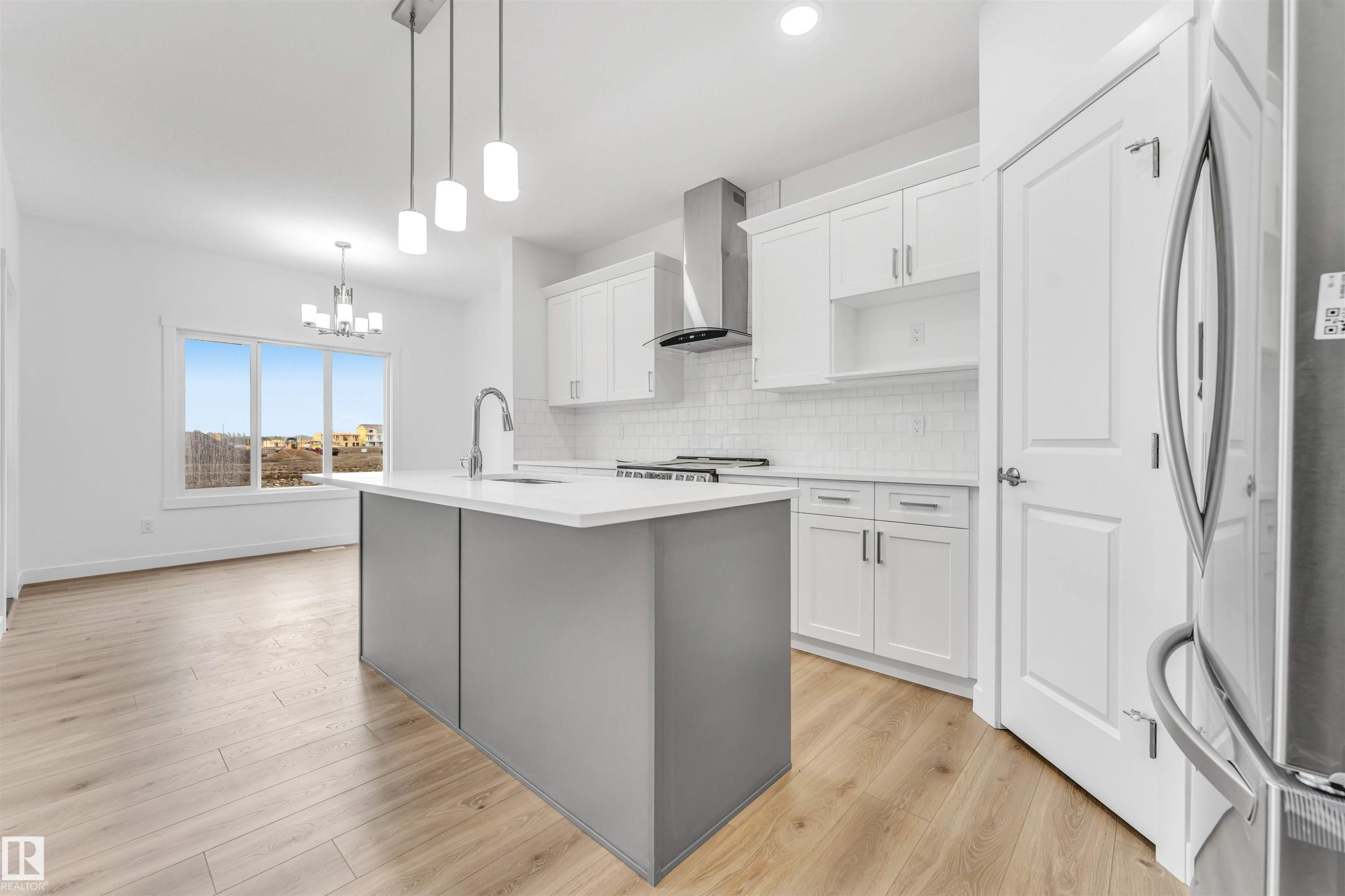 Modern kitchen featuring a grey island with a white countertop, white shaker-style cabinetry, and stainless steel appliances - 1972 210 Street, Edmonton, AB - Indoor Photo Showing Kitchen With Upgraded Kitchen