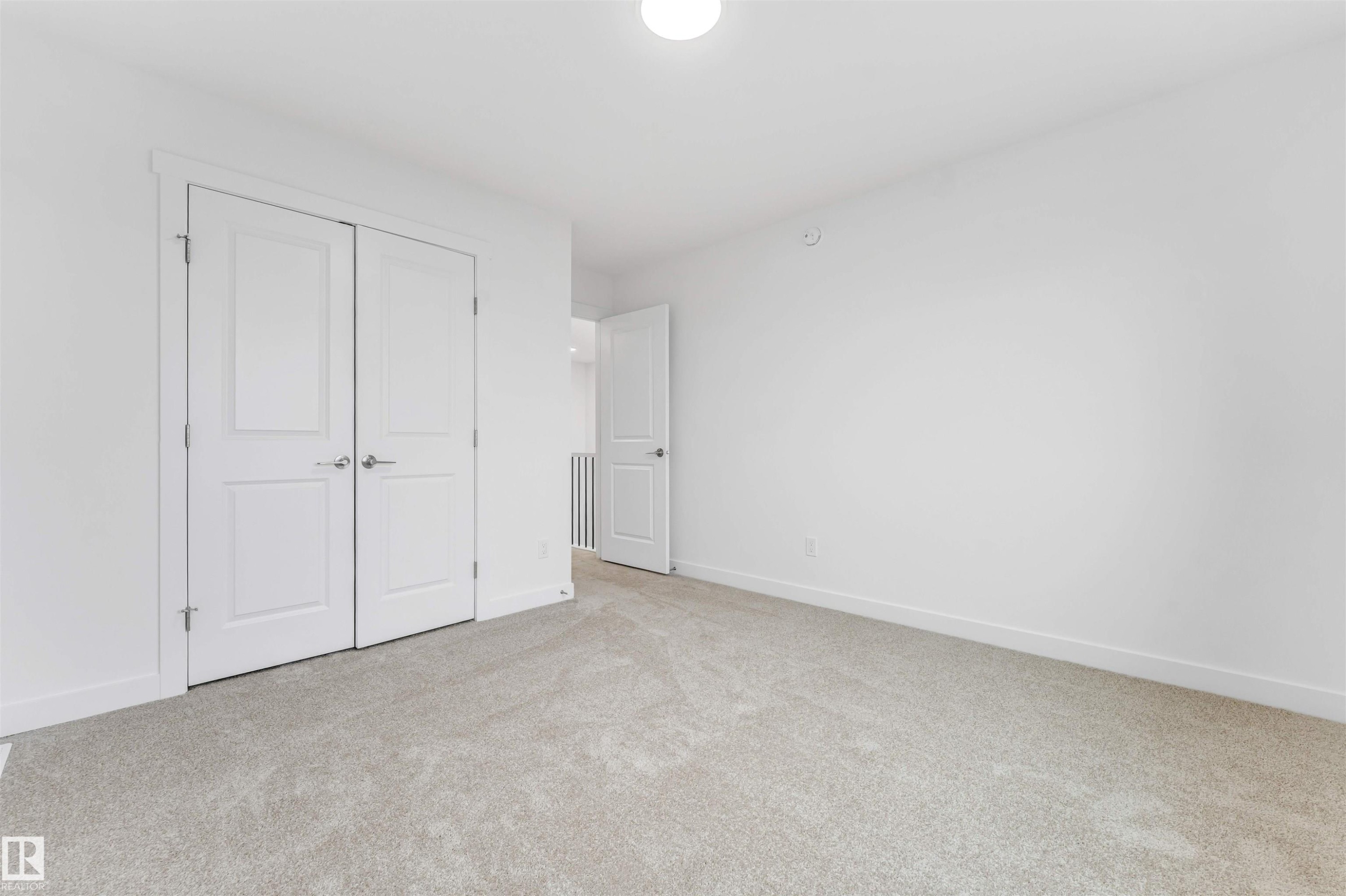 Carpeted room featuring white walls, white baseboards, a white ceiling, and a white flush-mount ceiling light - 1972 210 Street, Edmonton, AB - Indoor Photo Showing Other Room