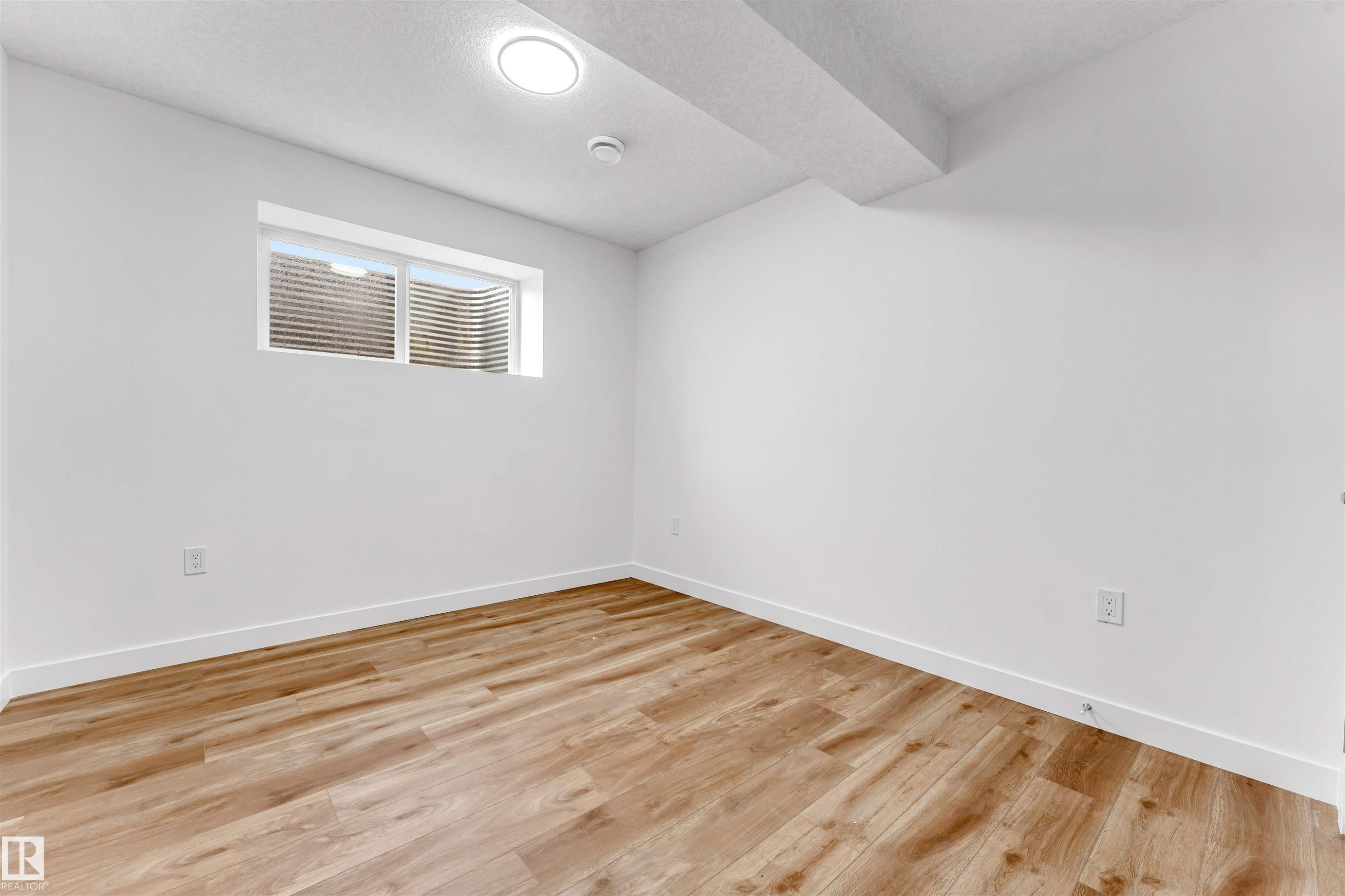 Bright room featuring wood-finish flooring, white walls, and a recessed ceiling light fixture - 1972 210 Street, Edmonton, AB - Indoor Photo Showing Other Room