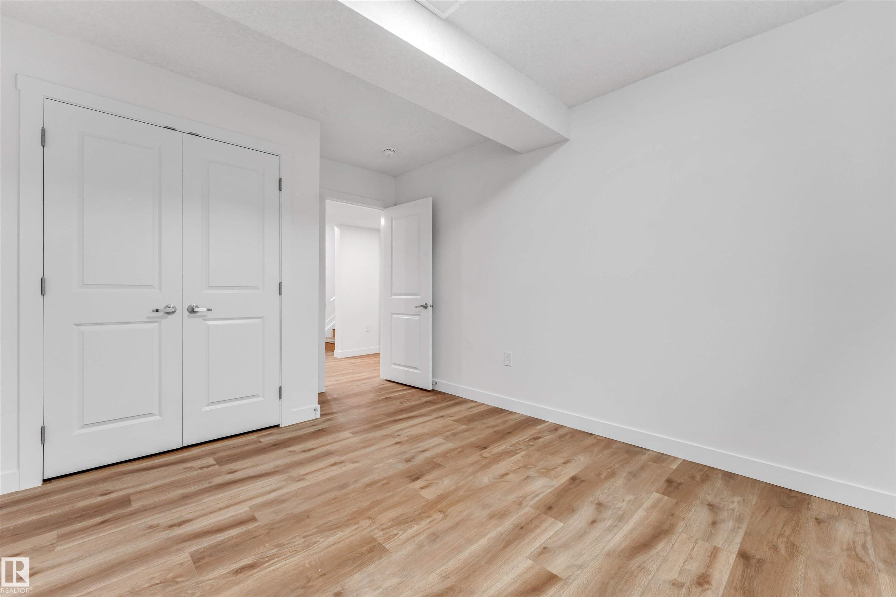 Room featuring wood-finish flooring, white walls, white baseboards, and a white ceiling - 1972 210 Street, Edmonton, AB - Indoor Photo Showing Other Room