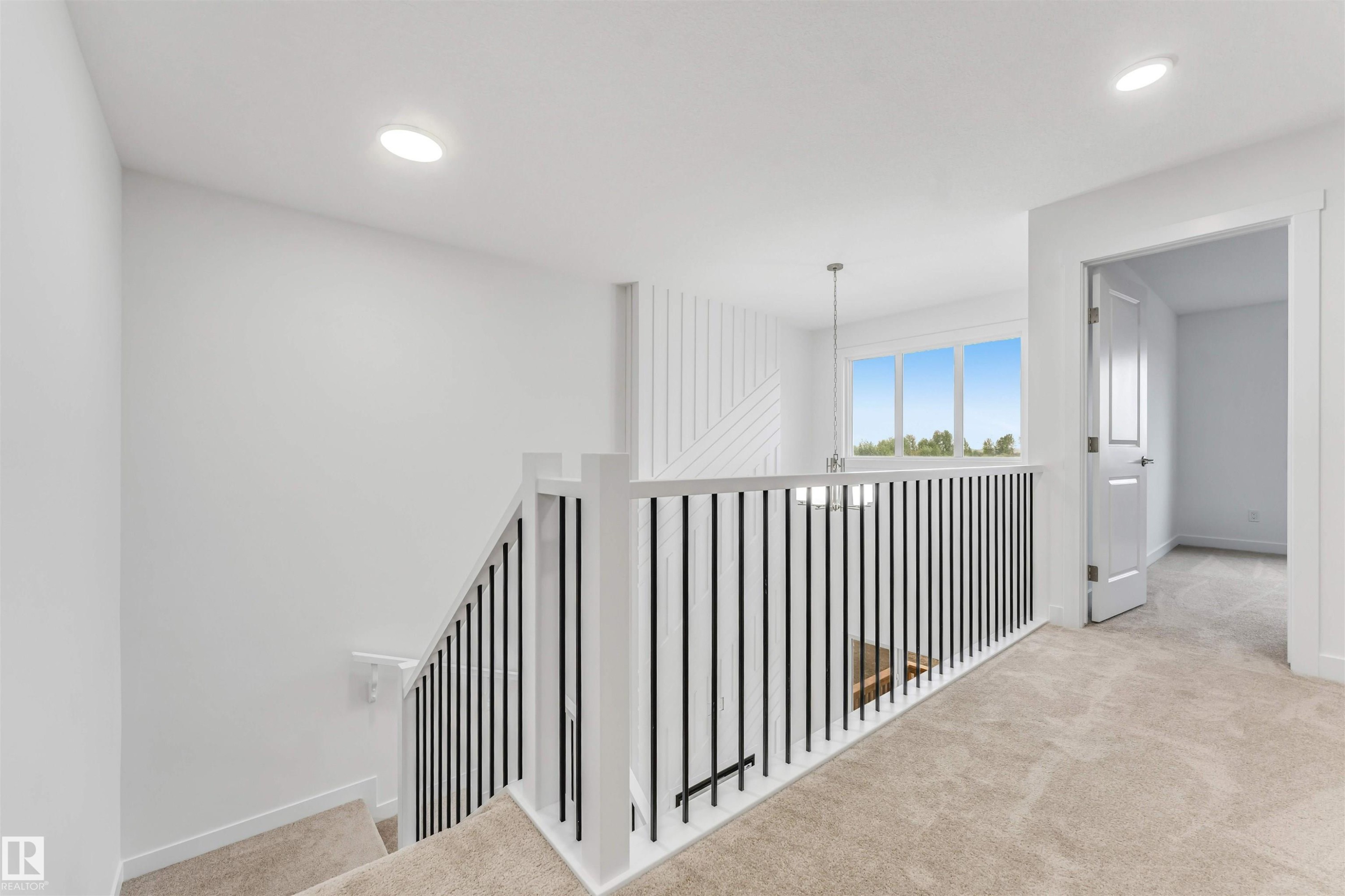 Upper-level landing featuring a white railing with black balusters, recessed lighting, and soft carpeting - 1972 210 Street, Edmonton, AB - Indoor Photo Showing Other Room