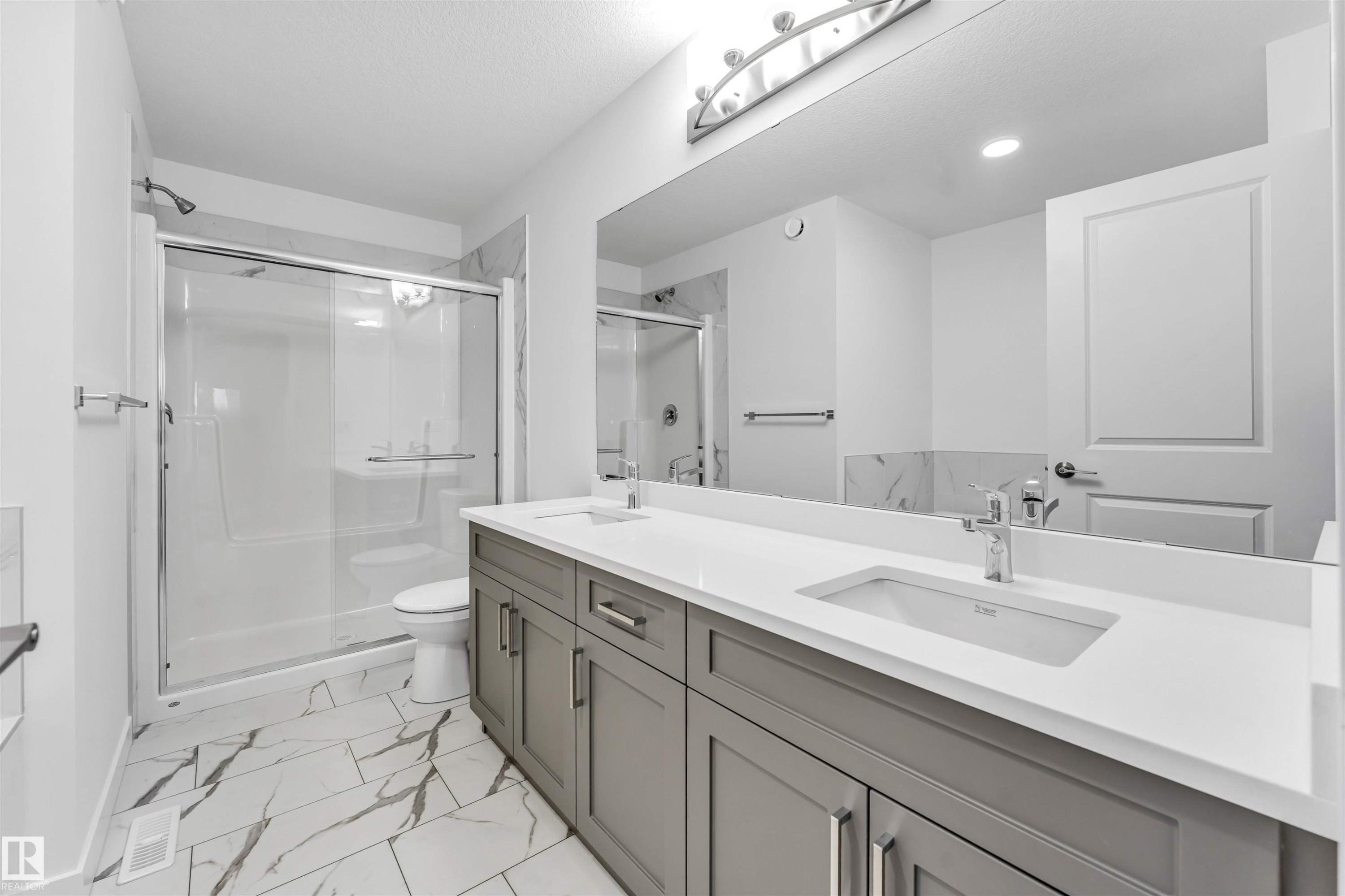 Spacious bathroom featuring a dual vanity with grey cabinetry and white countertops - 1972 210 Street, Edmonton, AB - Indoor Photo Showing Bathroom