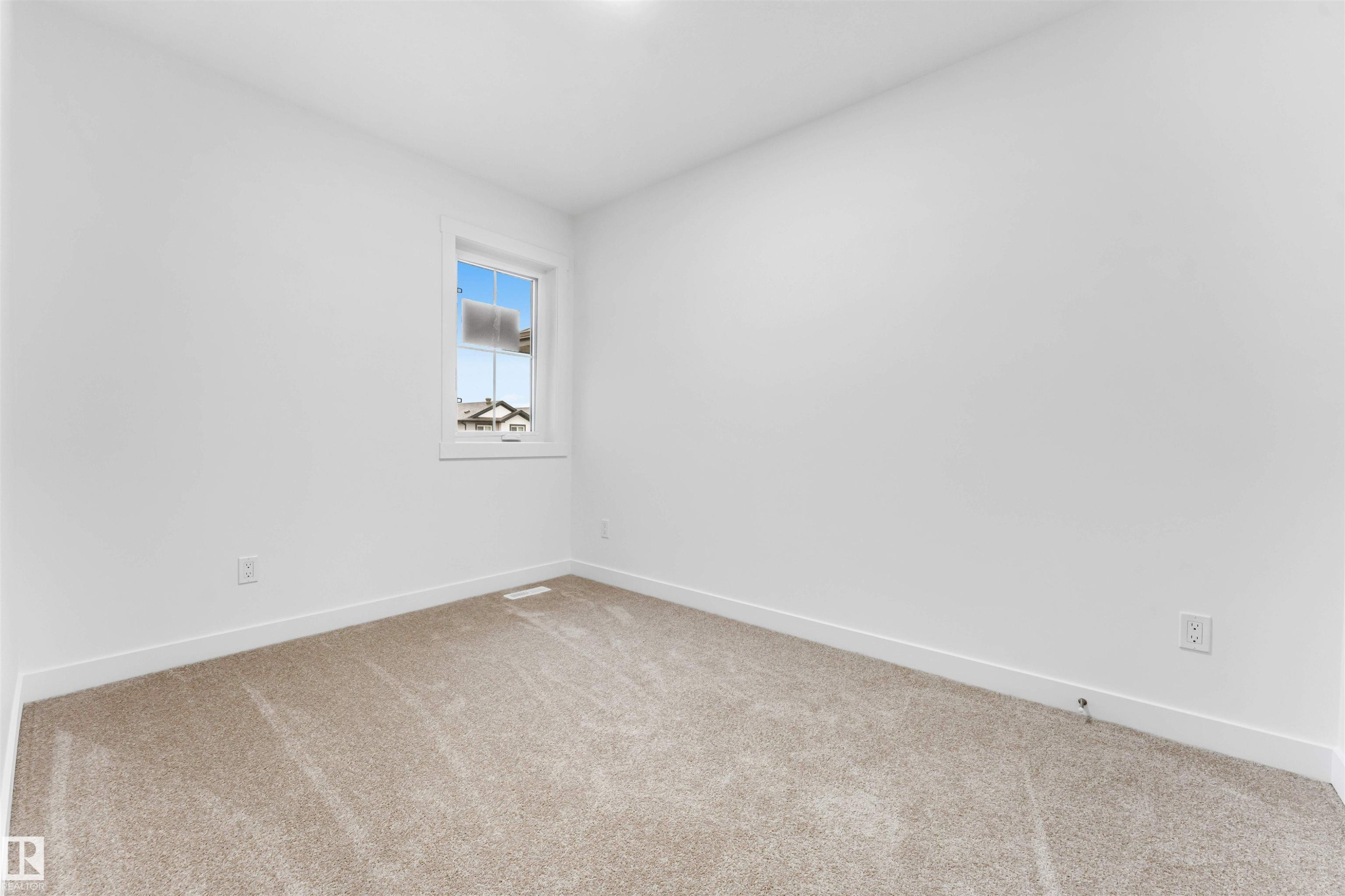 Bright room featuring light beige carpet, white baseboards, and a single window with white trim - 1972 210 Street, Edmonton, AB - Indoor Photo Showing Other Room