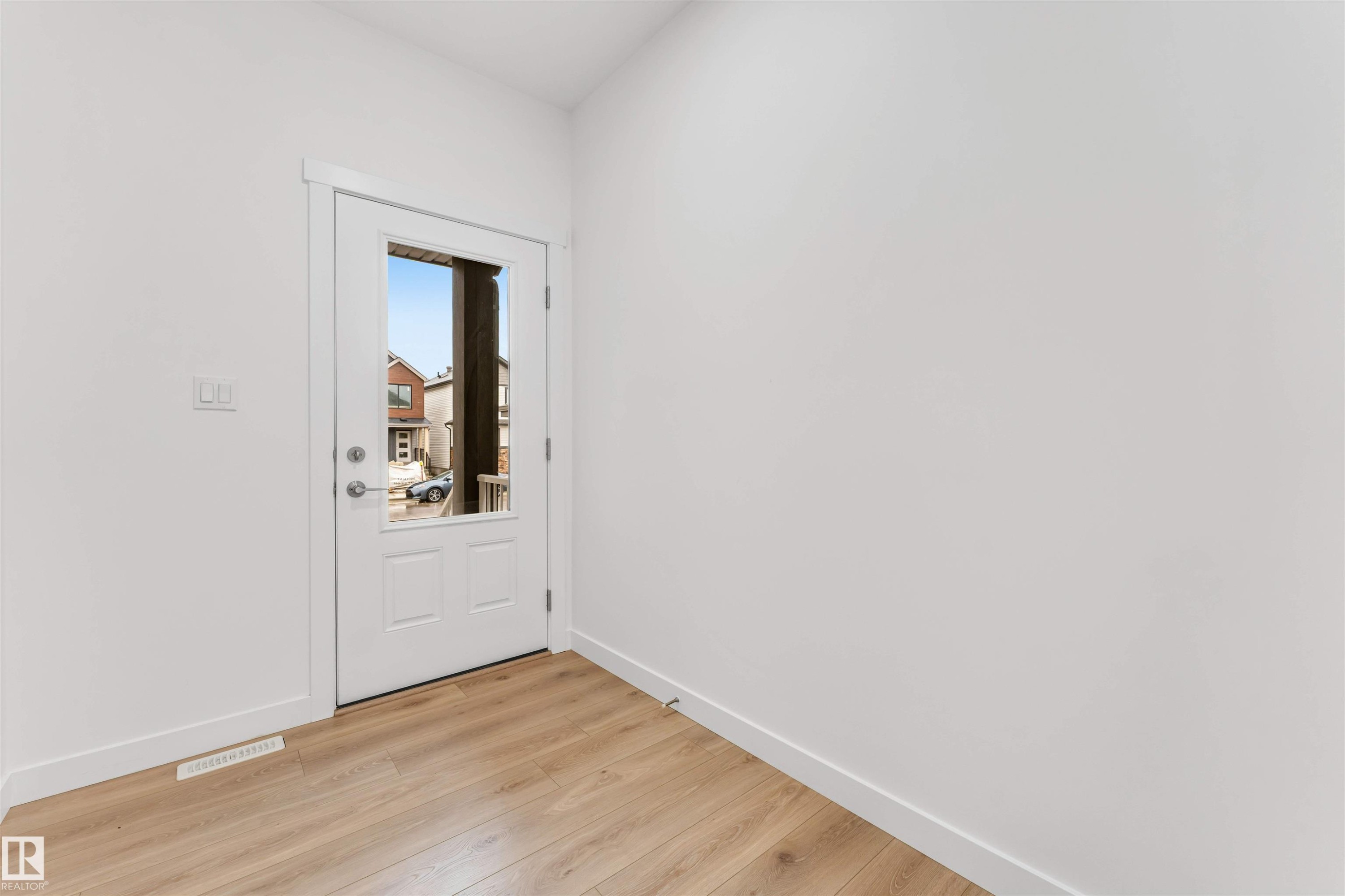 Entryway featuring a white door with a clear glass insert, wood-finish flooring, and crisp white trim - 1972 210 Street, Edmonton, AB - Indoor Photo Showing Other Room