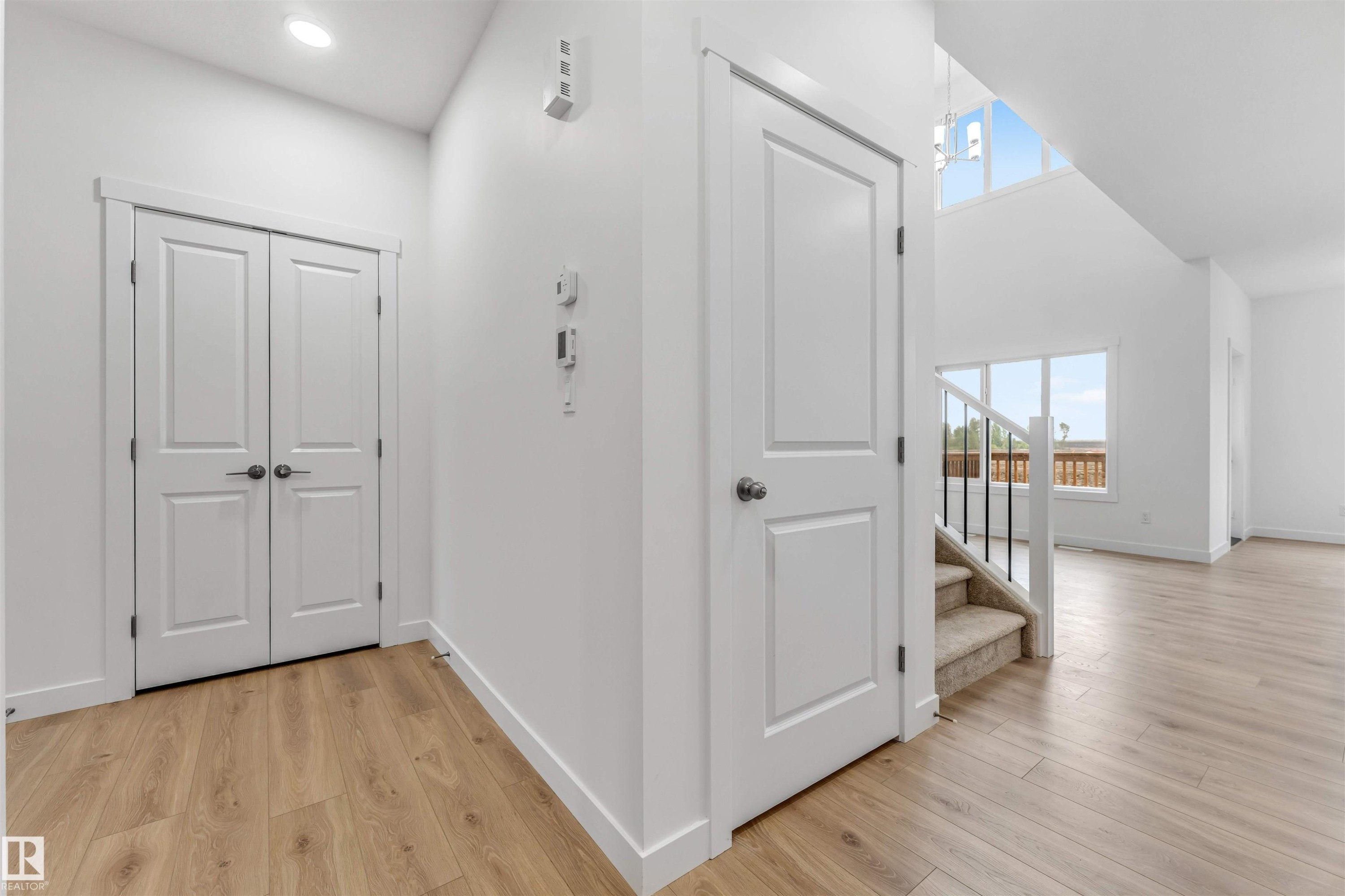 Light wood-finish flooring extending through the entry and into open living areas - 1972 210 Street, Edmonton, AB - Indoor Photo Showing Other Room