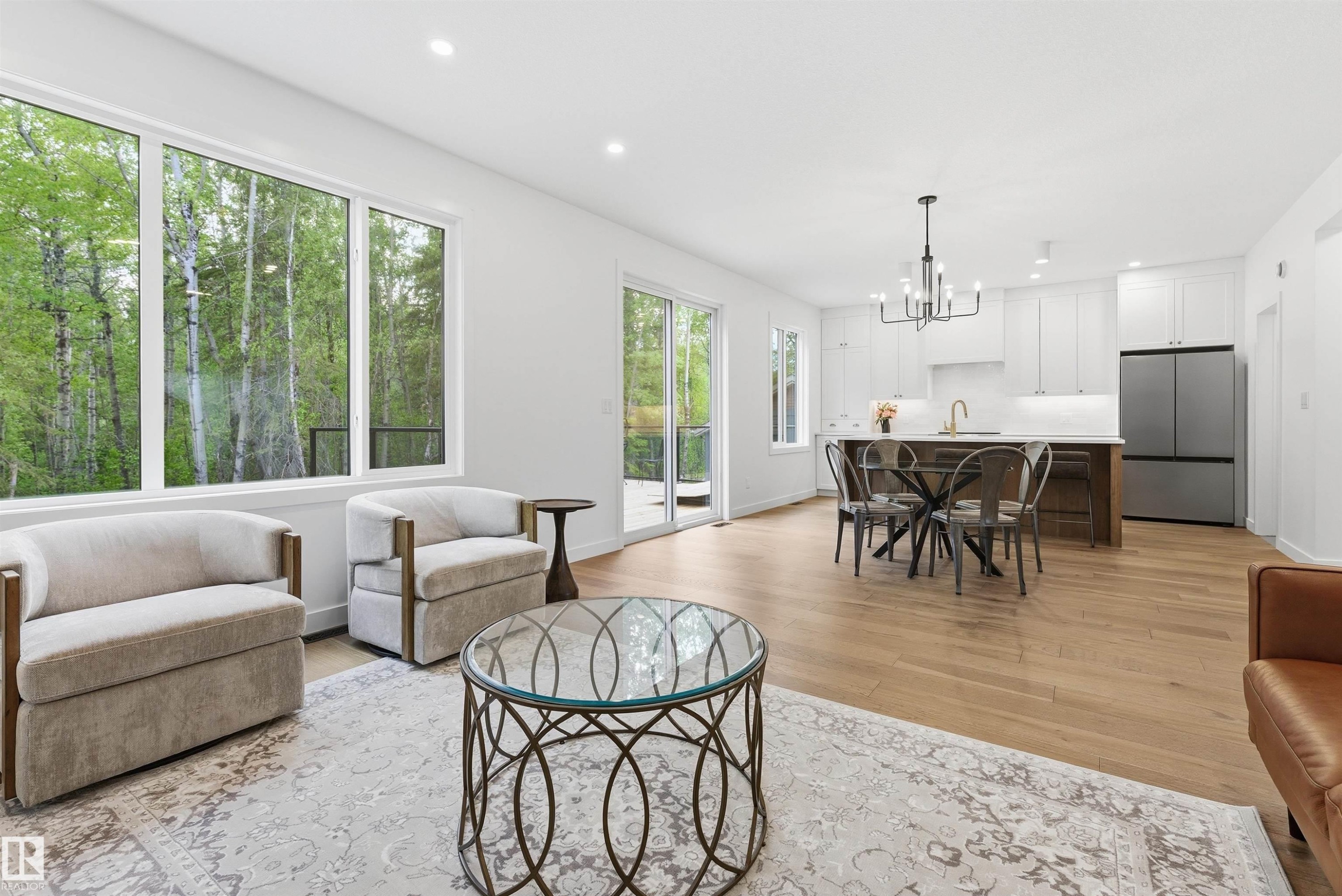 Open-concept living area with wood-finish flooring, recessed lighting, and large windows - 132 Heron Point Close, Rural Wetaskiwin County, AB