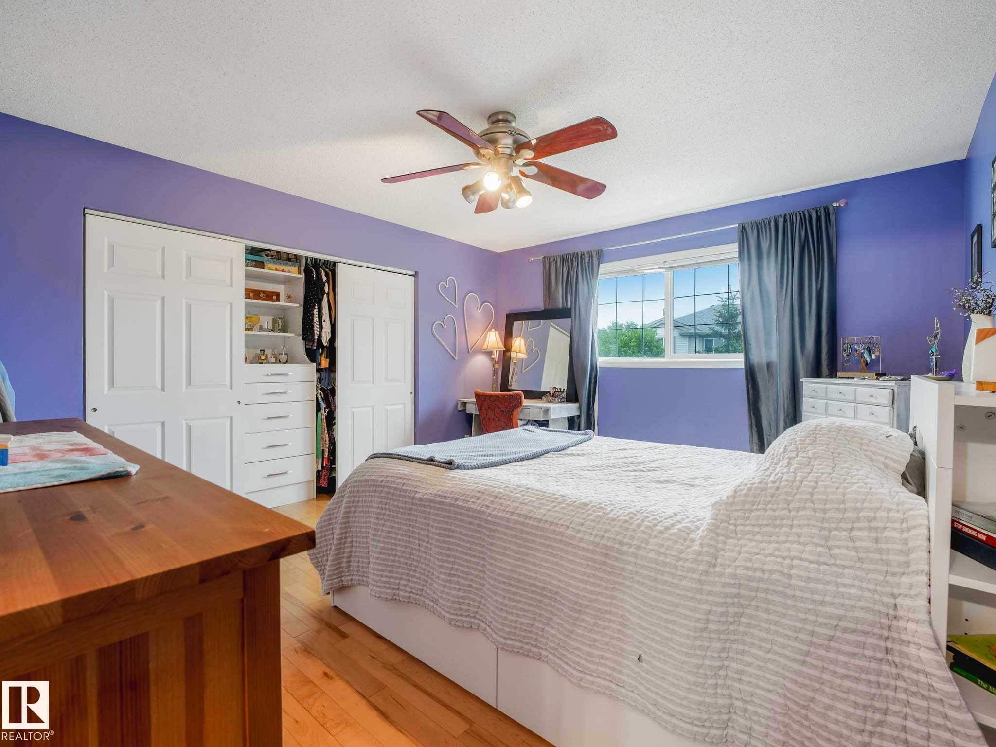 Bedroom featuring wood-finish flooring, a ceiling fan, and a window with blinds - 4031 38 Street, Edmonton, AB