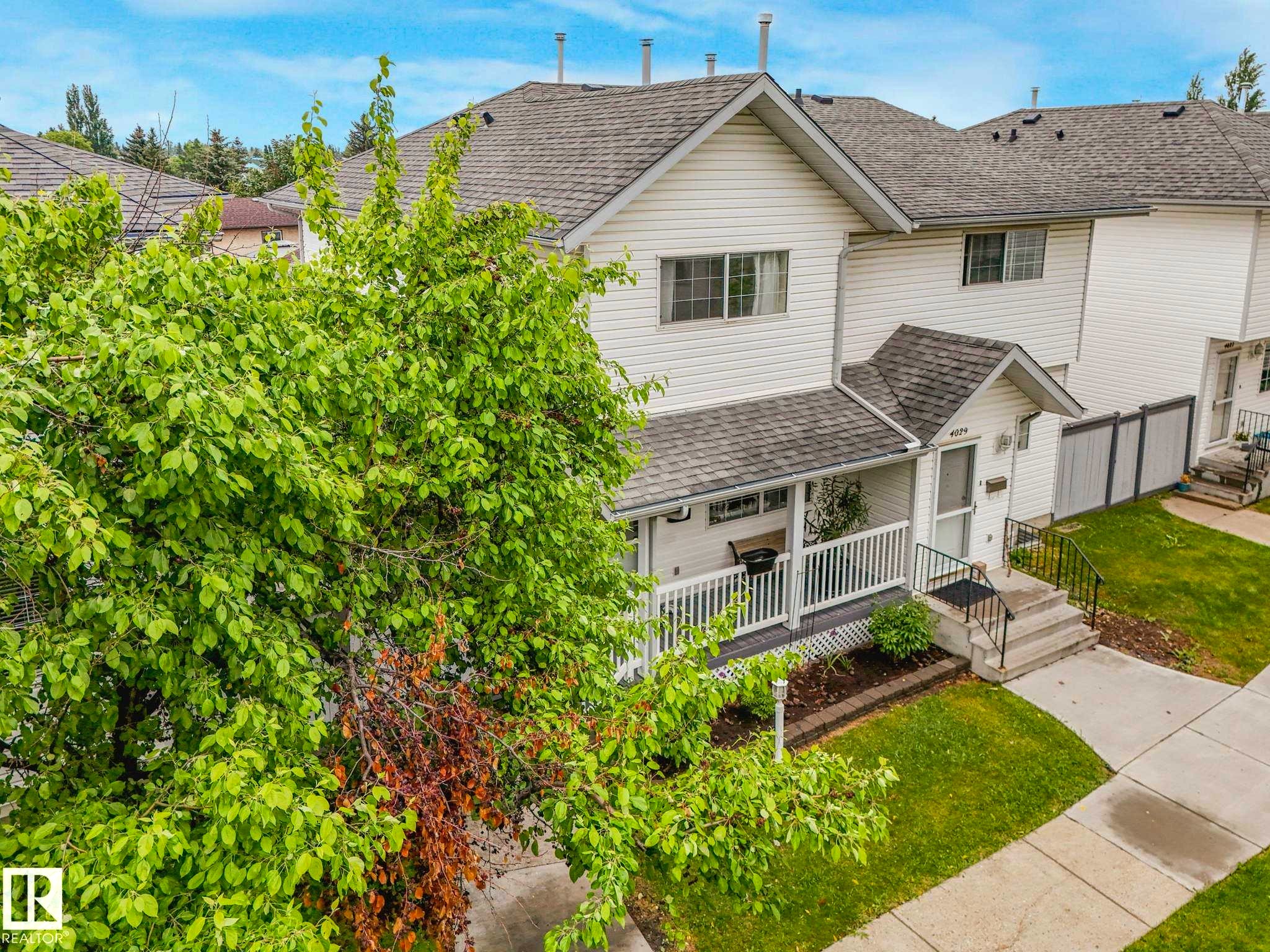 Two-story residence featuring white siding and a covered front porch with white railing - 4031 38 Street, Edmonton, AB
