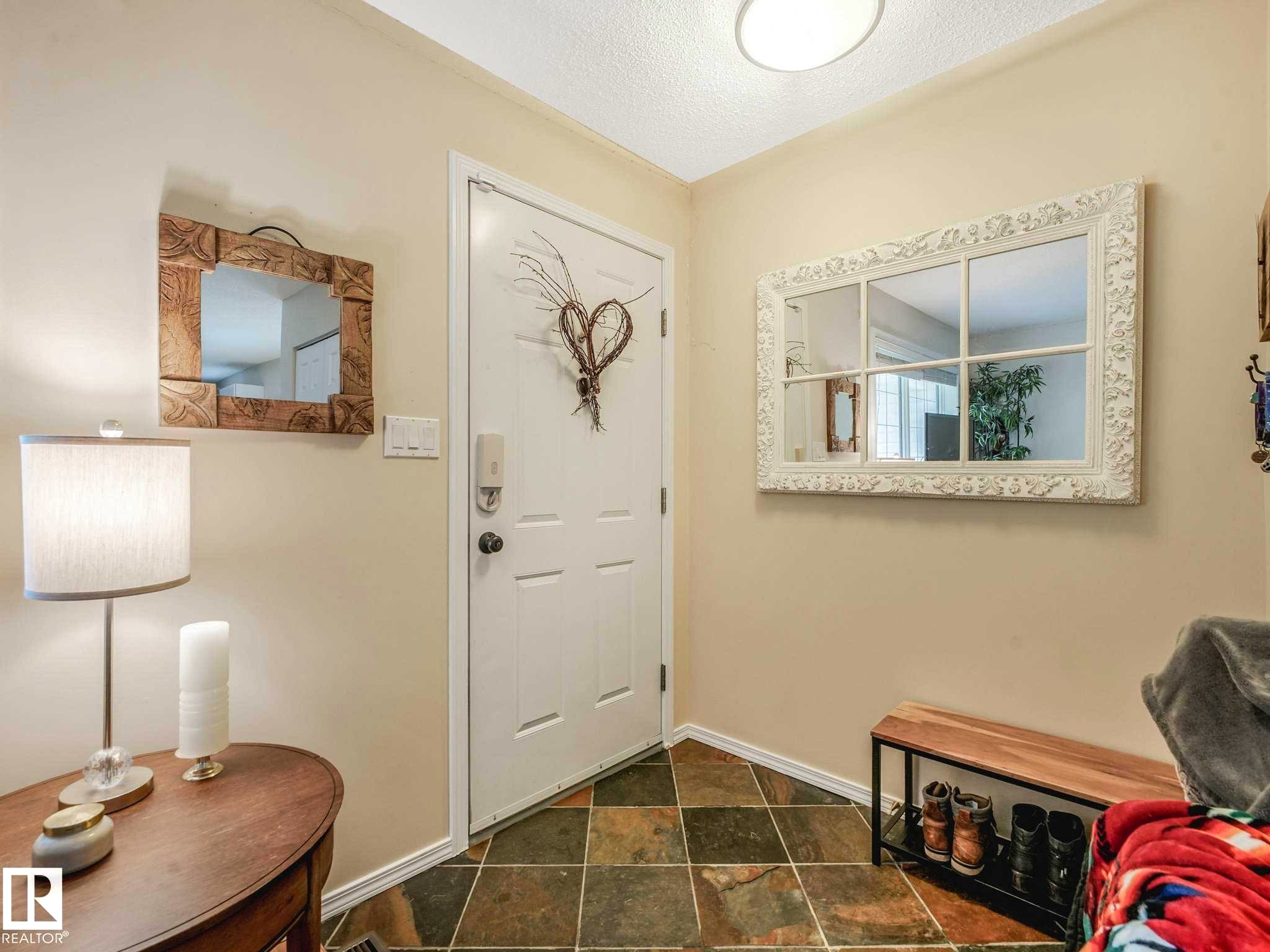 Entryway featuring slate tile flooring and a white paneled door - 4031 38 Street, Edmonton, AB