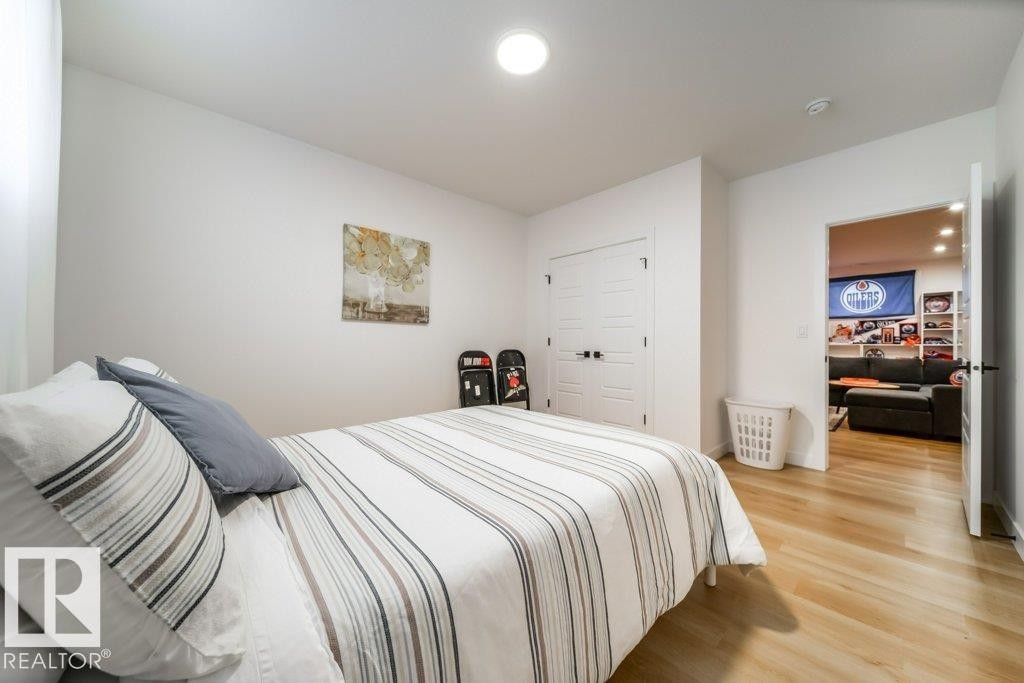 Bright room featuring light wood-finish flooring, white walls, and a ceiling-mounted light fixture - 11303 111 Avenue, Edmonton, AB - Indoor Photo Showing Bedroom