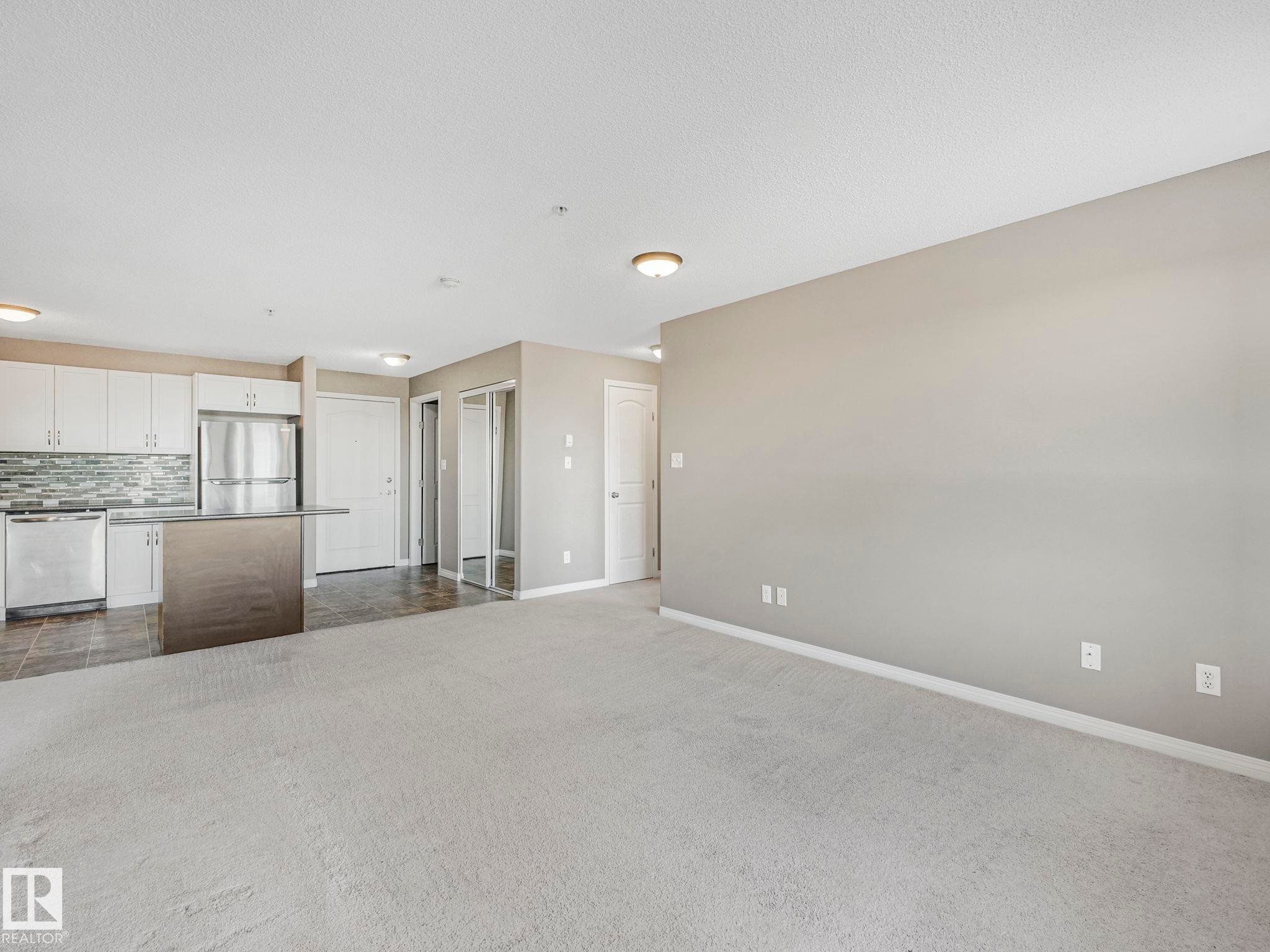 Open concept living space with light neutral carpeting - 322 1520 Hammond Gate Nw, Edmonton, AB - Indoor