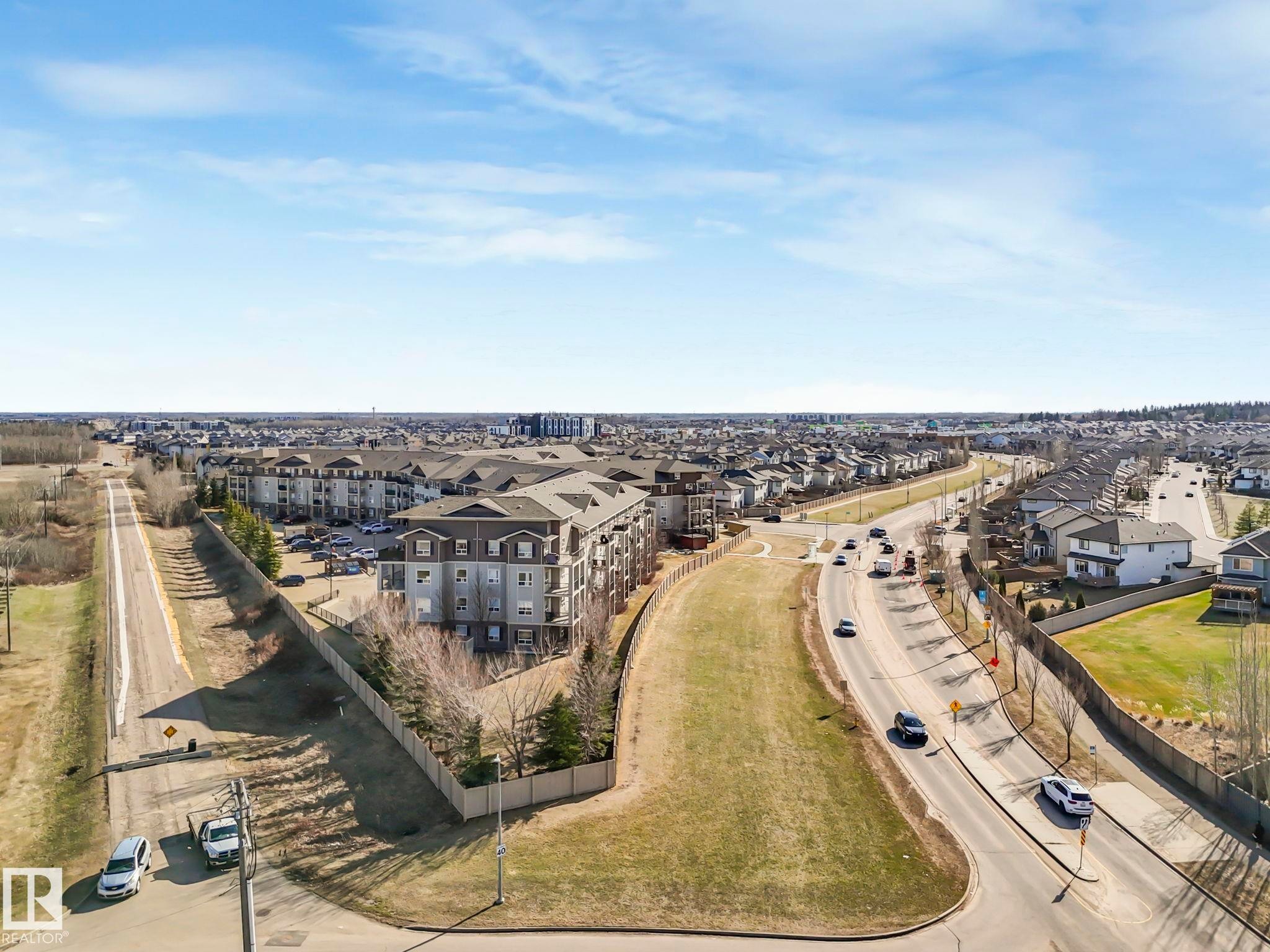 Expansive aerial perspective showcasing a neighborhood with a mix of multi-family and single-family residential properties - 322 1520 Hammond Gate Nw, Edmonton, AB - Outdoor With View