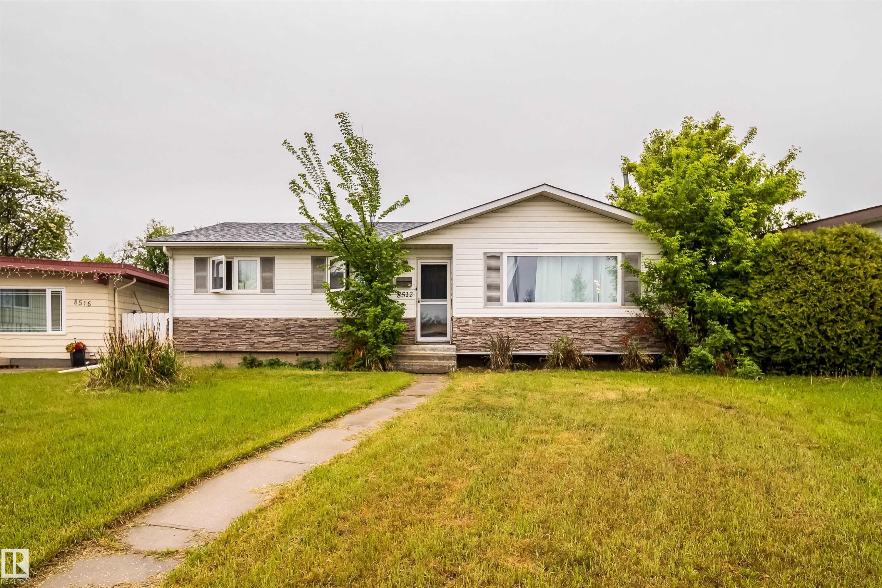 Ranch-style residence featuring white siding and a stone facade - 8512 142A Avenue, Edmonton, AB