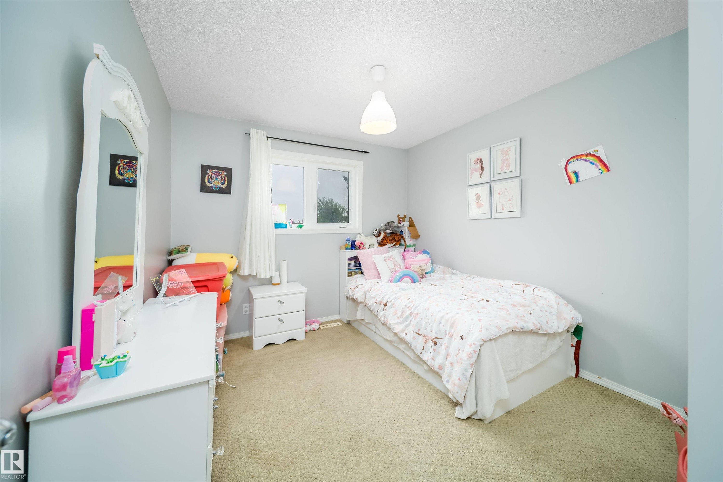 Neutral-toned wall paint and carpeting define this space, featuring a single window for natural light - 8512 142A Avenue, Edmonton, AB