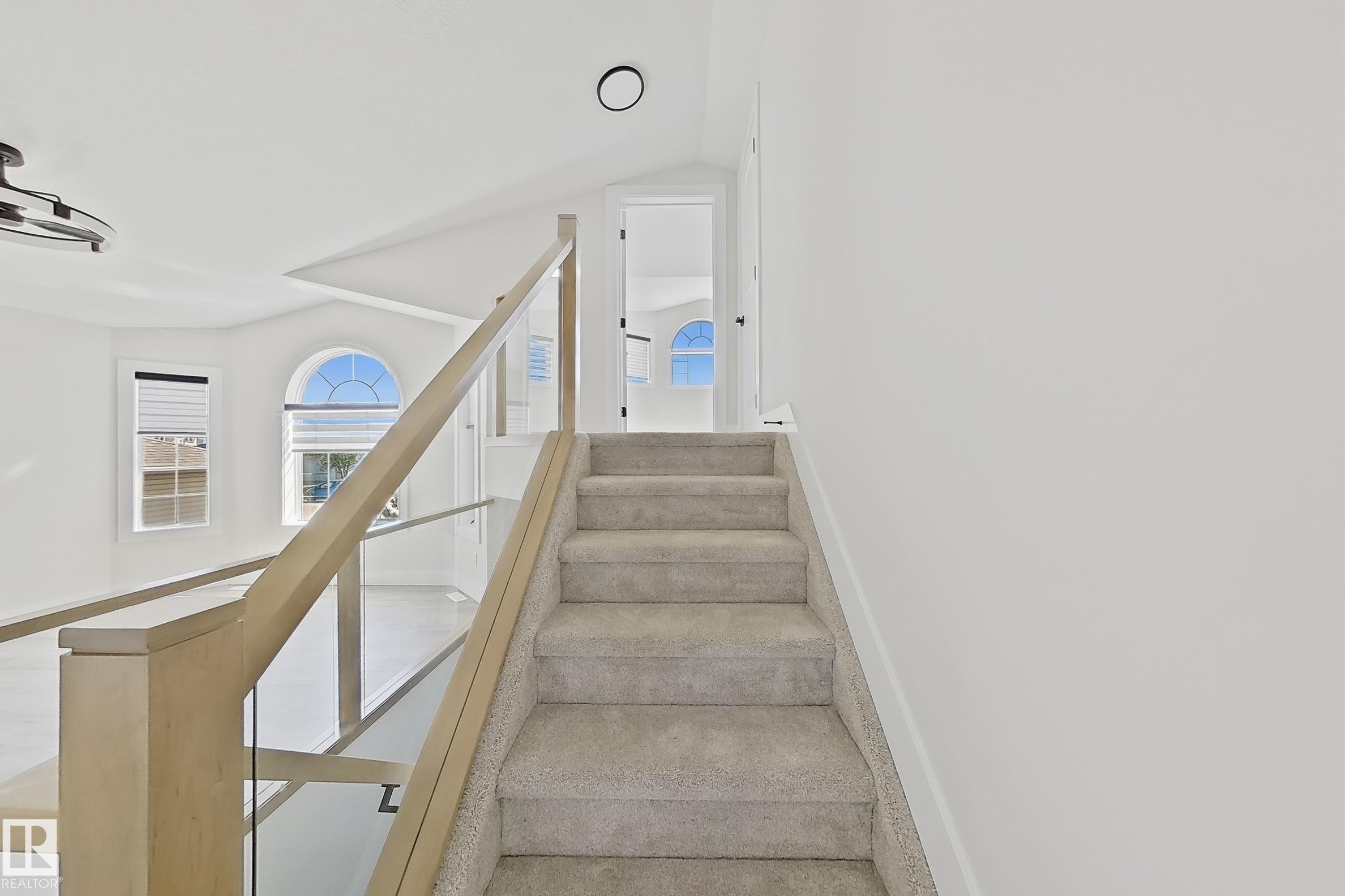 Carpeted staircase with light wood-finish and glass railing - 6144 166 Avenue, Edmonton, AB