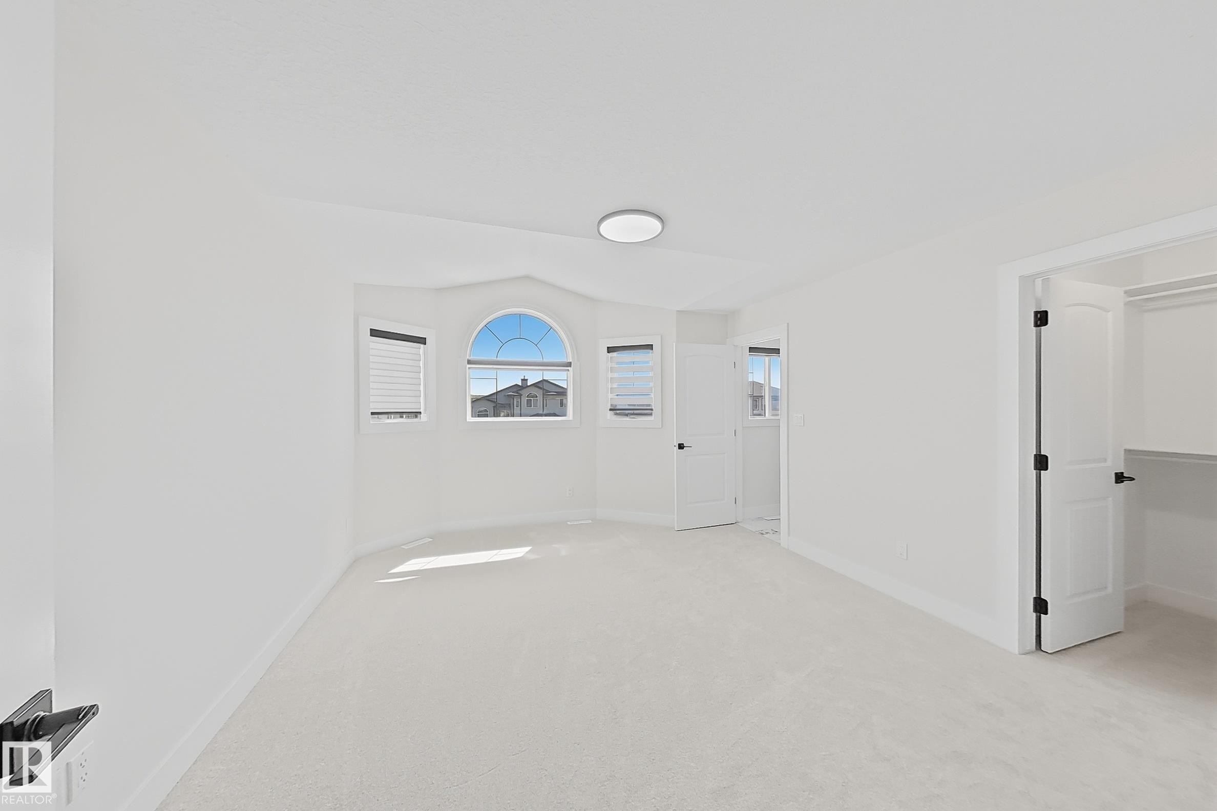 Bright room featuring light-colored carpeting, a ceiling-mounted light fixture, and white walls - 6144 166 Avenue, Edmonton, AB