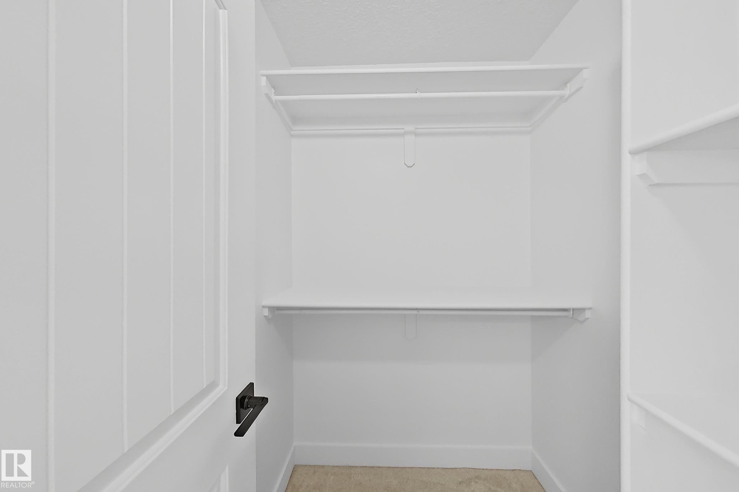 White walk-in closet featuring built-in shelving and hanging rods - 6144 166 Avenue, Edmonton, AB