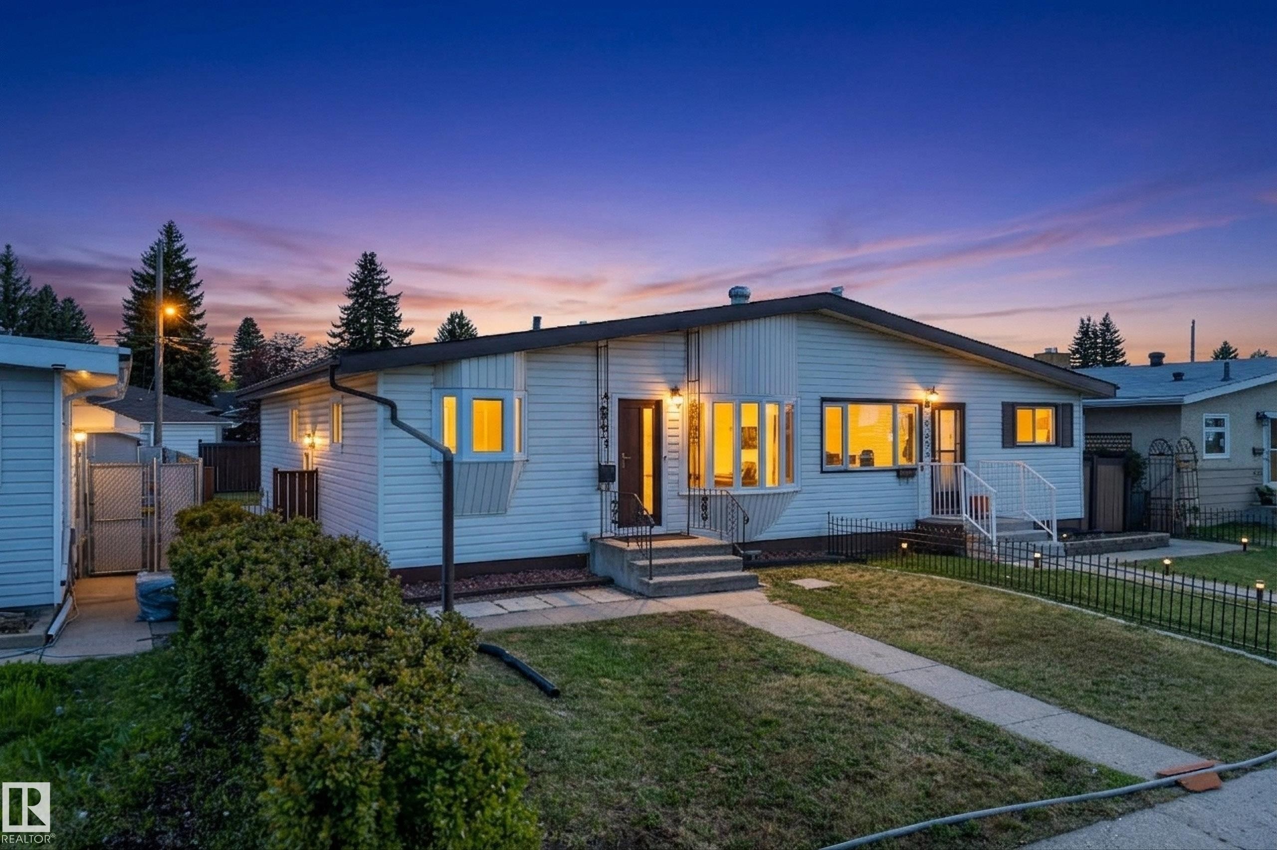 Single-story residence featuring white siding and a dark roofline - 6203 90 Avenue, Edmonton, AB
