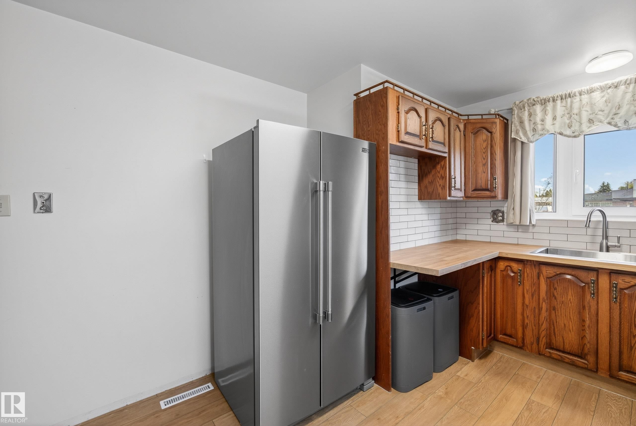 Kitchen featuring wood-finish flooring and solid wood cabinetry - 6203 90 Avenue, Edmonton, AB