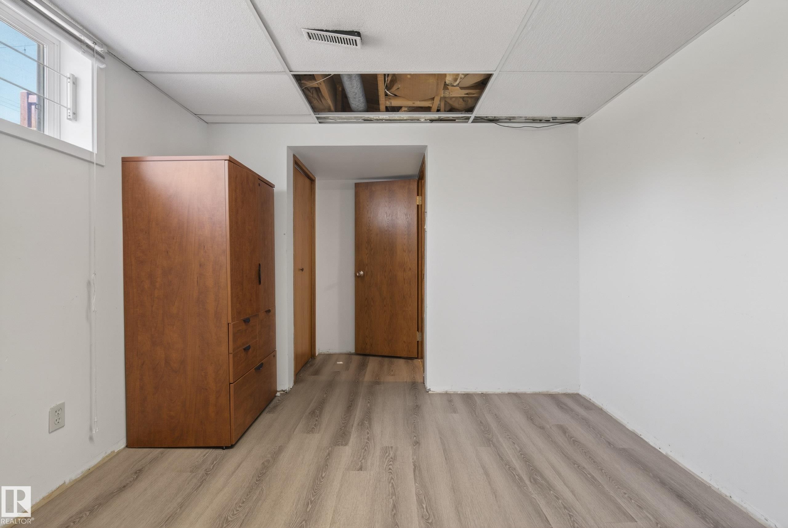 Wood-finish flooring with white baseboards throughout - 6203 90 Avenue, Edmonton, AB