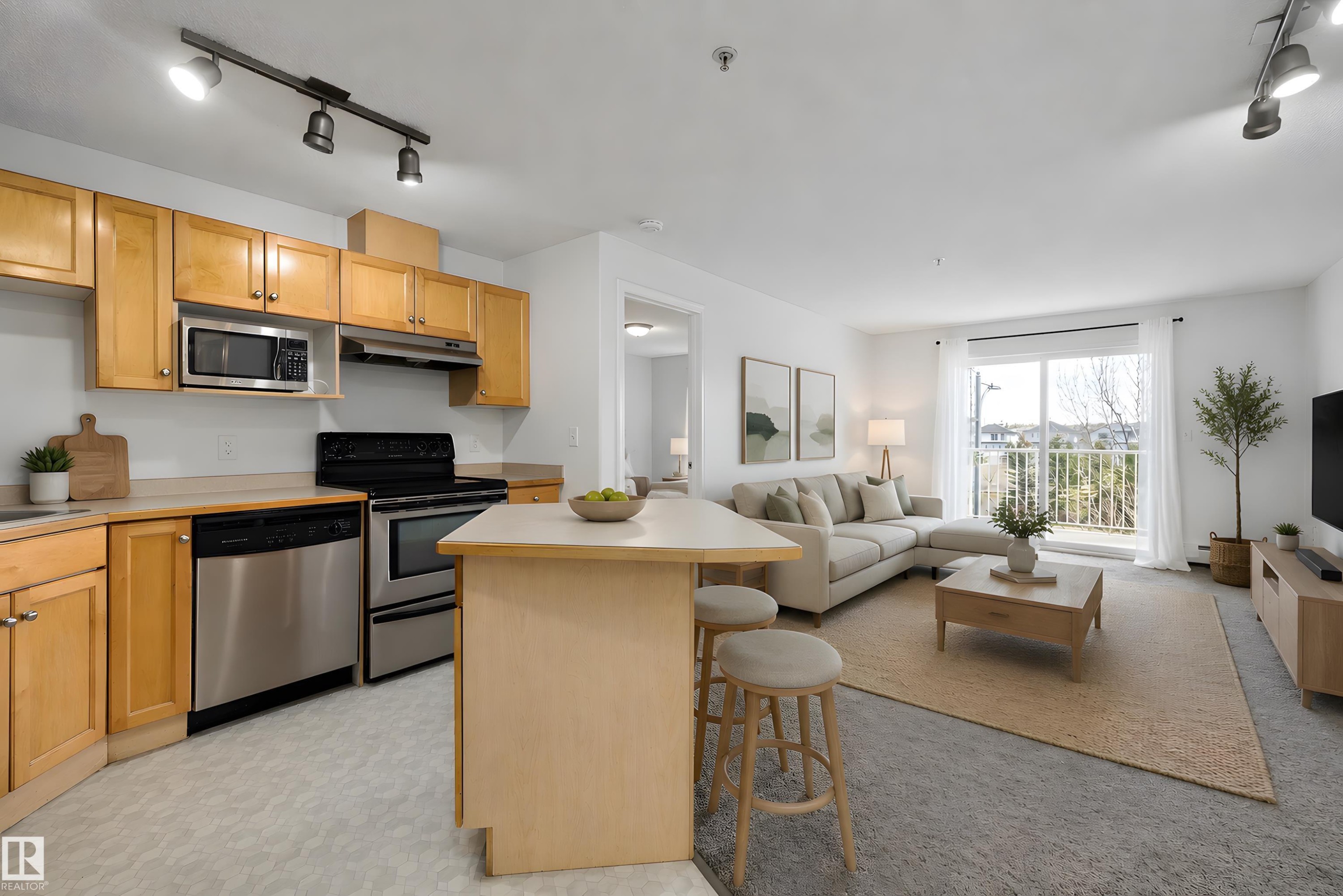 Open-concept living area featuring a kitchen with light wood cabinetry and stainless steel appliances - 320 245 Edwards Drive, Edmonton, AB