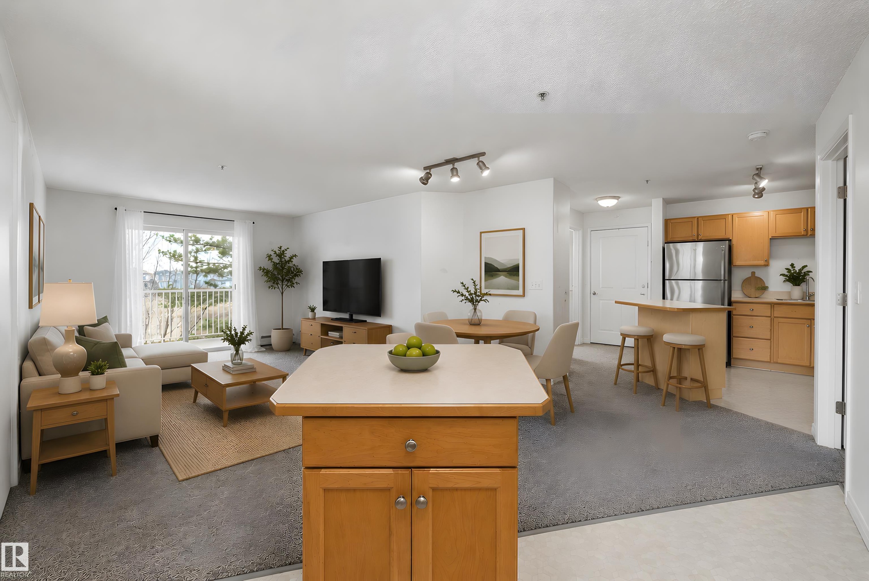 Open-concept living area featuring light wood-finish cabinetry, stainless steel appliances, a balcony, recessed lighting, and track lighting - 320 245 Edwards Drive, Edmonton, AB