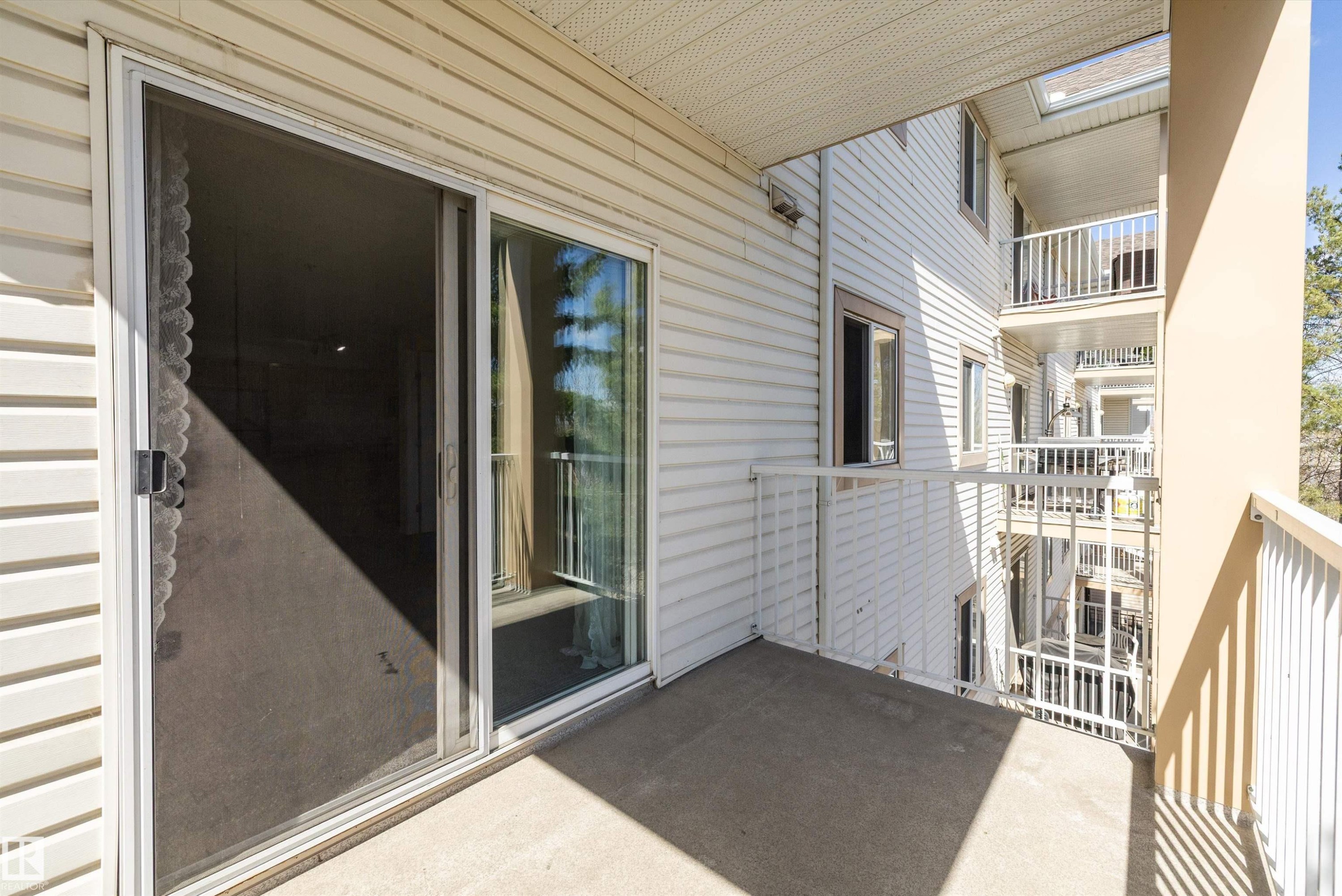 Private balcony with concrete flooring, white metal railing, and siding exterior - 320 245 Edwards Drive, Edmonton, AB