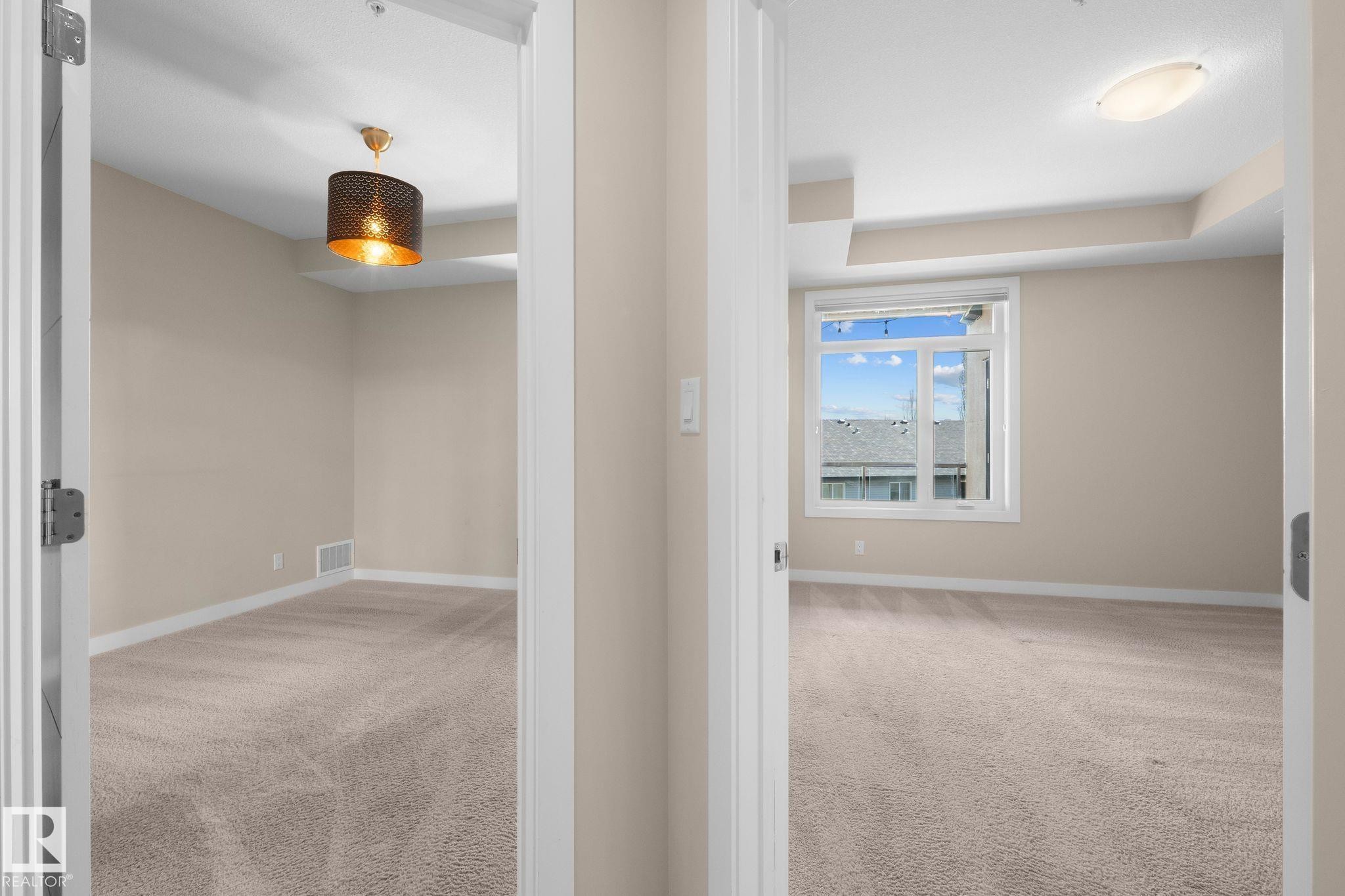Two carpeted rooms featuring neutral wall tones and white trim - 309 625 Leger Way, Edmonton, AB