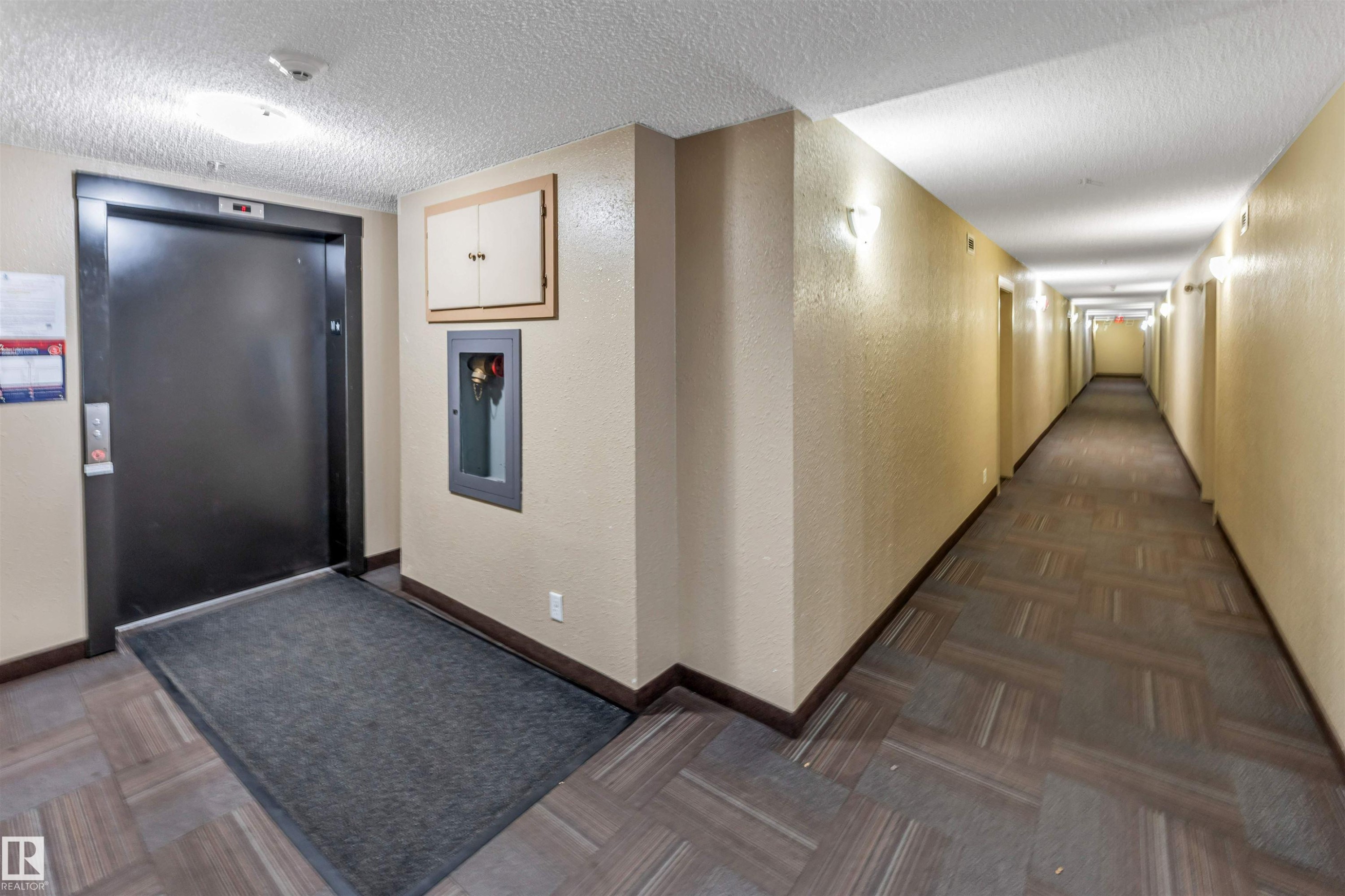 Corridor featuring patterned carpet flooring, neutral wall tones, and recessed wall sconces - 320 534 Watt Boulevard, Edmonton, AB - Indoor Photo Showing Other Room