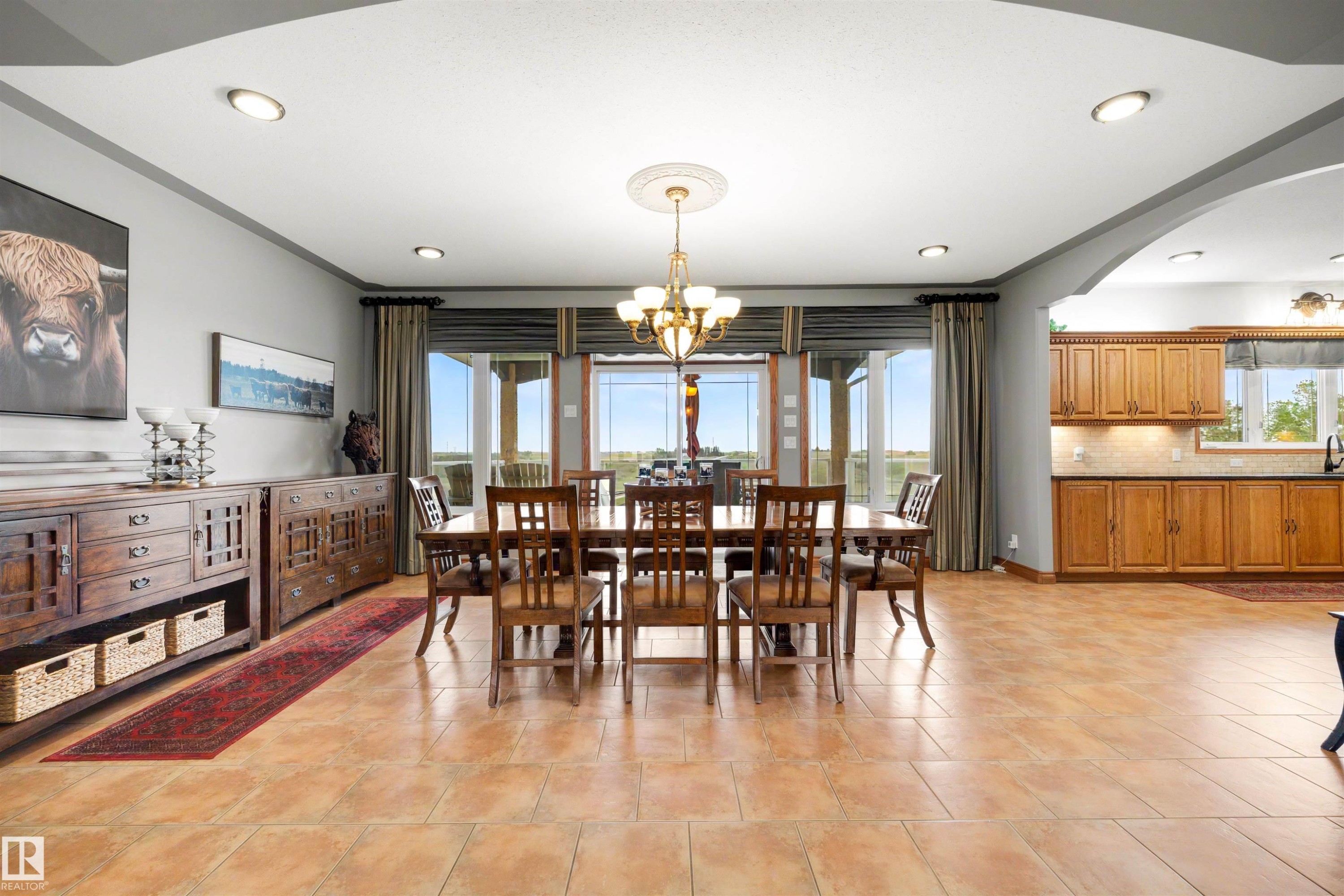 Spacious dining area featuring large format tile flooring, recessed lighting, and an elegant chandelier with a ceiling medallion - 28125 Highway 587, Rural Red Deer County, AB - Indoor Photo Showing Dining Room